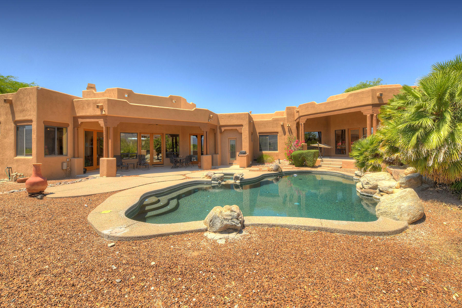 Stunning home nestled on hillside in Tanque Verde Valley. This Southwest beauty on 1.66 acres affords Spectacular Mountain Views & Resort-like Backyard. Enter the Great Room which features Soaring ceilings w/wall of windows to appreciate the views. Kitchen opens to Great Room for a bright open feel throughout. Split floorplan has Master suite w/access to backyard resort area. A Den/office is located near Master Suite & two Guest bedrooms & bath on other side. This house offers a Separate wing which is an Entertainment or Home Office delight! Wing contains; Billiard room/Activity Room w/gas fireplace & wet bar, Large Gym, Sound-proof home theater/media room wired for A/V equip, Library, Office & full bath w/access to backyard pebble tec pool/spa with a Rock Waterfall. Welcome Home!