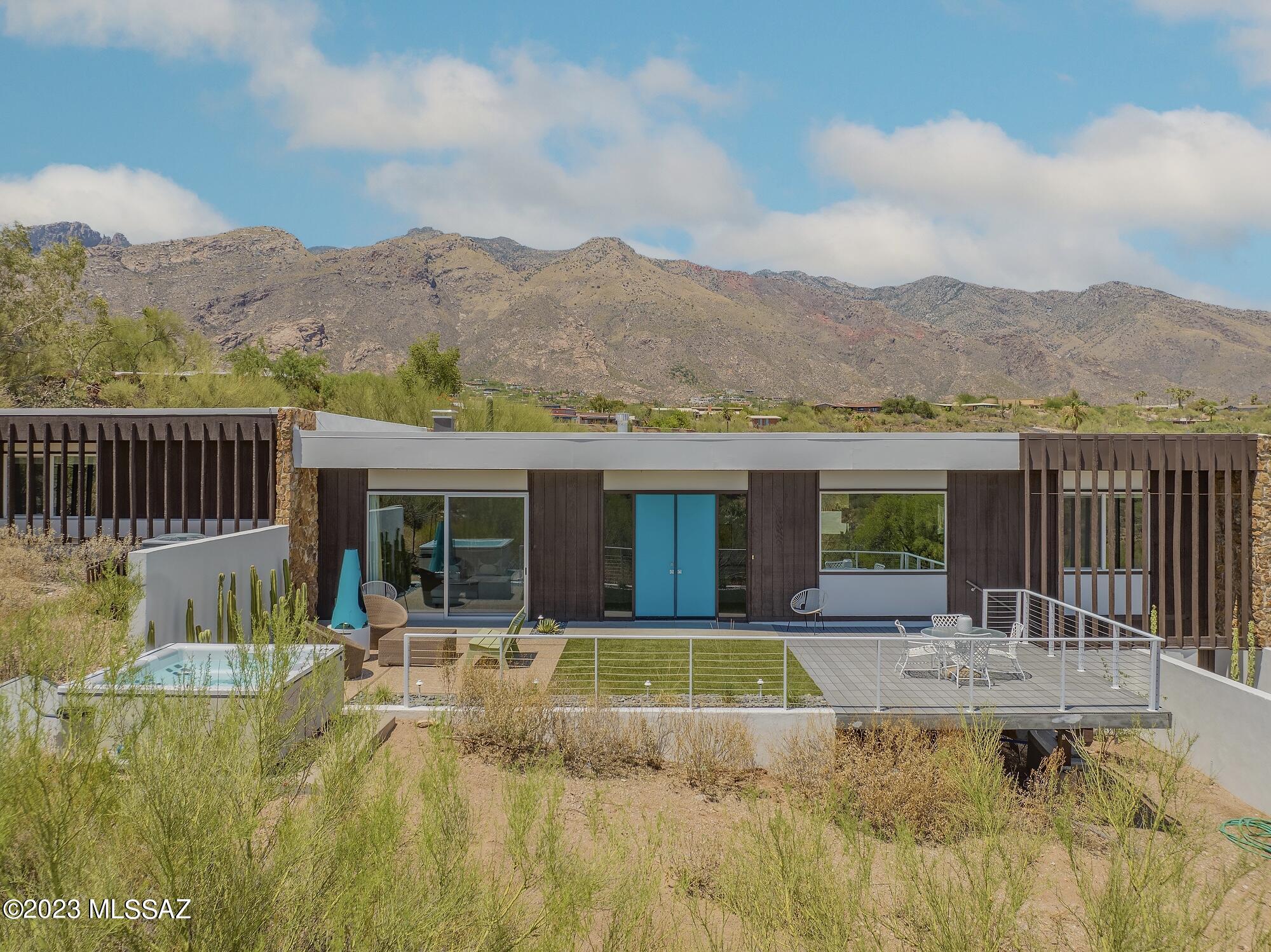 With extraordinary attention to detail, this iconic residence offers a harmonious fusion of preservation and progress.
This rare Midcentury home was designed by Dale Birtch and constructed in 1968 on a premium parcel in the Catalina Foothills. Situated in the Skyline Bel Air Estates neighborhood, it is just steps to amenities including tennis courts and the community pool.
The combination of native stone, mahogany, and turquoise accents create a serene palette against the stunning city and mountain views. Refined finishes were utilized to meticulously update the interior and exterior spaces. The owners enlisted a team of local design and remodeling experts to curate improvements while embracing the original intentions. Kathryn Prideaux of Prideaux Design together with the Firm of Repp+Mclain skillfully renovated the kitchen, bathrooms and laundry room. The comprehensive restoration project included all new flooring, windows, patio doors, and numerous systems upgrades. Prideaux Designs also transformed the back yard in 2020 with the addition of a pool, fire features, and synthetic grass terrace. The comprehensive restoration project included all new flooring, windows, patio doors, and numerous systems upgrades. The result is a home which radiates the vitality of our Sonoran desert while embracing the unique history of this phenomenal home.
The main floor plan is open in feeling but balances intimate spaces for dining, entertaining, and lounging all with panoramic views of the desert. The spacious kitchen island is clad in marble and is the centerpiece of the sophisticated chef's kitchen. Just beyond in the dining area a cantilevered fireplace with copper hood is complimented by coordinating pendant lights. Numerous built ins throughout offer style and storage. Timeless design principles guided custom selections throughout the home. Both the primary and guest bathrooms have quartz counters, period colors and handmade tiles. 
Enjoy the gracious primary suite with walk-in closet, en suite bathroom, and sparkling city light views. Three additional bedrooms each with large closets and views. Generous laundry room with additional storage and cabinetry.
Both north and south yards are configured to take advantage of sweeping views. Concrete and stone are softened by soft custom benches and a stunning lap pool with Baja shelf for reading or relaxing. Low maintenance plantings introduce organic green hues which juxtapose against crisp white walls and furnishings. LED lighting and thoughtful automation make this home a year round retreat.
A two car garage with storage, three car carport, owned solar electric system, 30,000+ square foot lot, and district 16 schools all contribute to this being not only an extraordinary residence but an efficient and convenient place to enjoy all that Tucson has to offer.