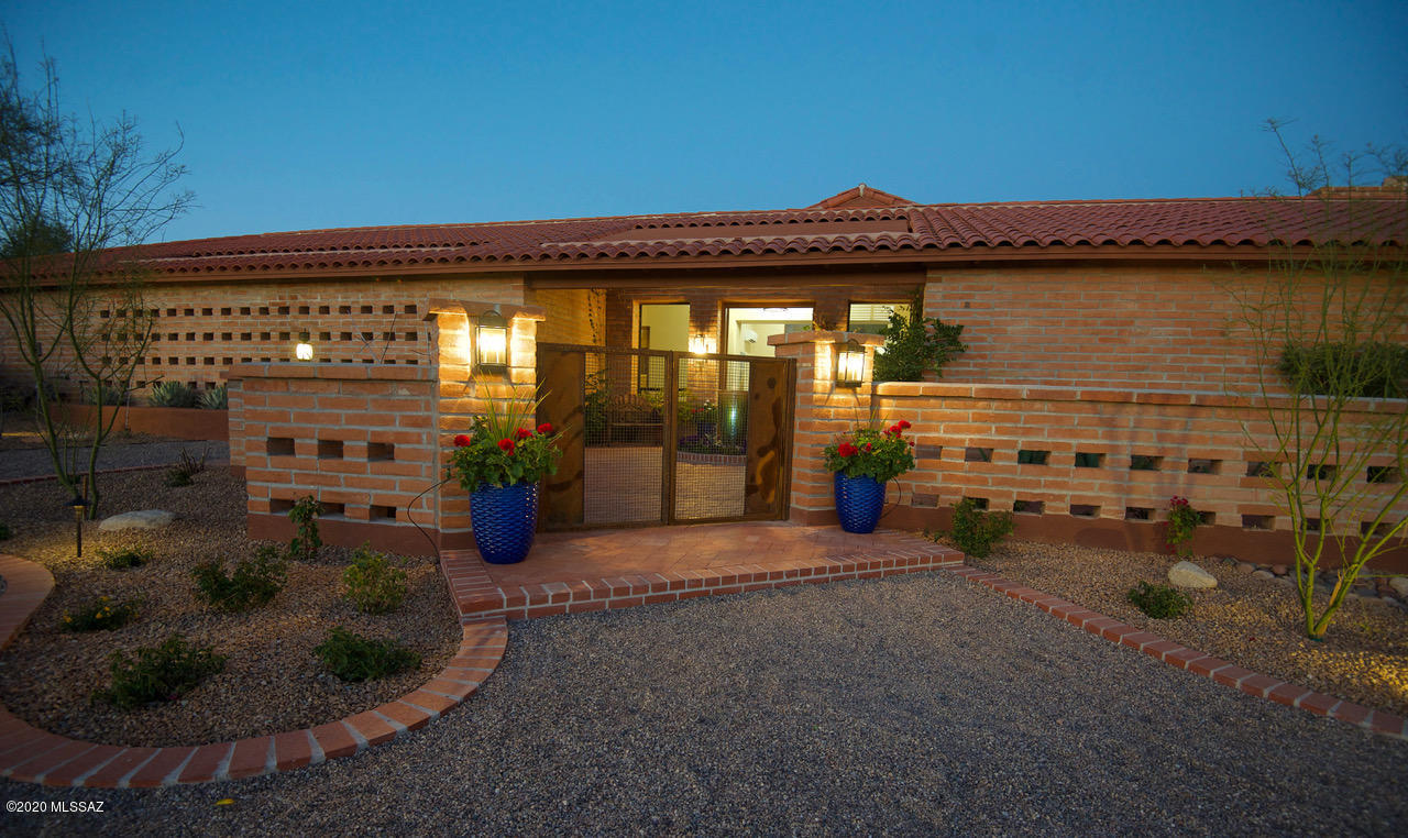 Accepting backup offers. Lots of WOW! Beautifully updated home. The front gated courtyard welcomes you with a lighted fountain and lush landscaping. Open the 10 foot high metal clad front doors and enter into the newly added living room with 14 foot high ceilings and dramatic wall of custom Pella windows framing a breathtaking double saguaro with mountain backdrop. Travertine floors & showers. Gourmet kitchen w/live-edged granite counters. SS appliances, gas cooktop, new Bosch microwave drawer & dishwasher, dbl oven, wine refrigerator, washer and steam dryer. Updated bathrooms, jetted master tub, jetted master shower panel. Large backyard w/Pebbletec pool, dbl saguaro, mtn view. Private covered master bedroom patio and a covered BBQ patio. Split bedroom plan. N/S facing. Owner/agent