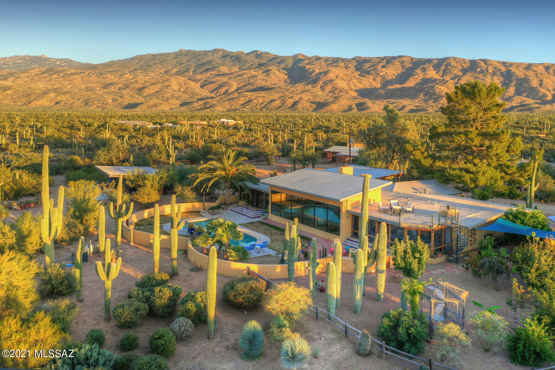 ''The Notch,'' a beautiful spot at the base of the Rincon Mt's & Saguaro National Monument East. This Sonoran Ranch home is sited on nearly 5 acres  w/outstanding Catalina Mt views.  Handsome horse ranch offers; evap cooled barn w/expansive turnouts, fly spray system, wash stall, tack room, hay barn, round pen & large arena.  Trailhead access to 83,000 acre National Park is 1/2 block away. The 3719 sq ft home has 9' high, 36' long wall of glass framing spectacular Catalina Mt. views.  The primary bedroom includes a FP, private screened porch & a  gorgeous ensuite bathroom w/shower & separate soaking tub & large walk in closet. Large open great room has a gas FP. Kitchen has Italian Rhino white marble center island & counter tops, and handmade Tabarka tile back splash 3 bedrooms 3 bathrooms plus office & work out room, which could be used as a 4th bedroom plus office.  Separate heated and cooled Art Studio. Heated salt-water pool, fenced orchard, view deck, and covered patio with Koi pond add to this incredible home.  New well installed prior to close of escrow.  Separate 2 car garage and workshop.