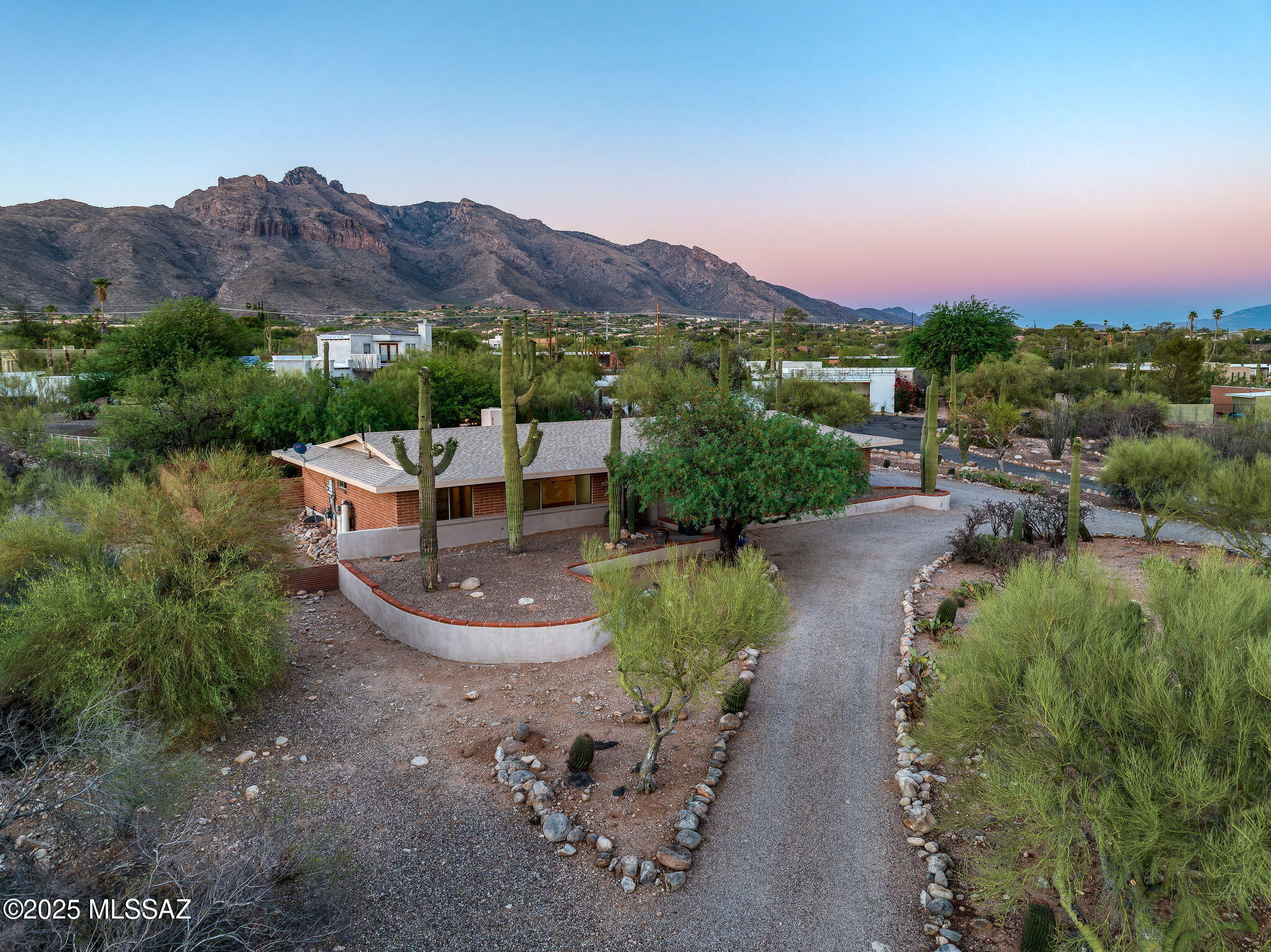 Beautifully remodeled home set against the Catalina Foothills, offering a spacious, well-designed layout w/ attention to detail throughout. Gourmet kitchen features custom white cabinetry, granite-topped center island, abundant counter space, SS appliances, & designer lighting. Kitchen opens to a bright, window-lined great room w/ cantera stone FP & adjacent dining area. Outdoor living enhanced by a large covered patio, brick pavers, EZ-care turf, & mature landscaping. Primary suite features custom closet, elegant chandelier, & updated ensuite bath. Two lovey guest rooms + versatile den w/ large picture window. Guest bath updated in similar quality. Oversized laundry rm & ample garage storage. Located on .78-acre lot in Dist 16, close to La Encantada, shopping, dining & top schools.