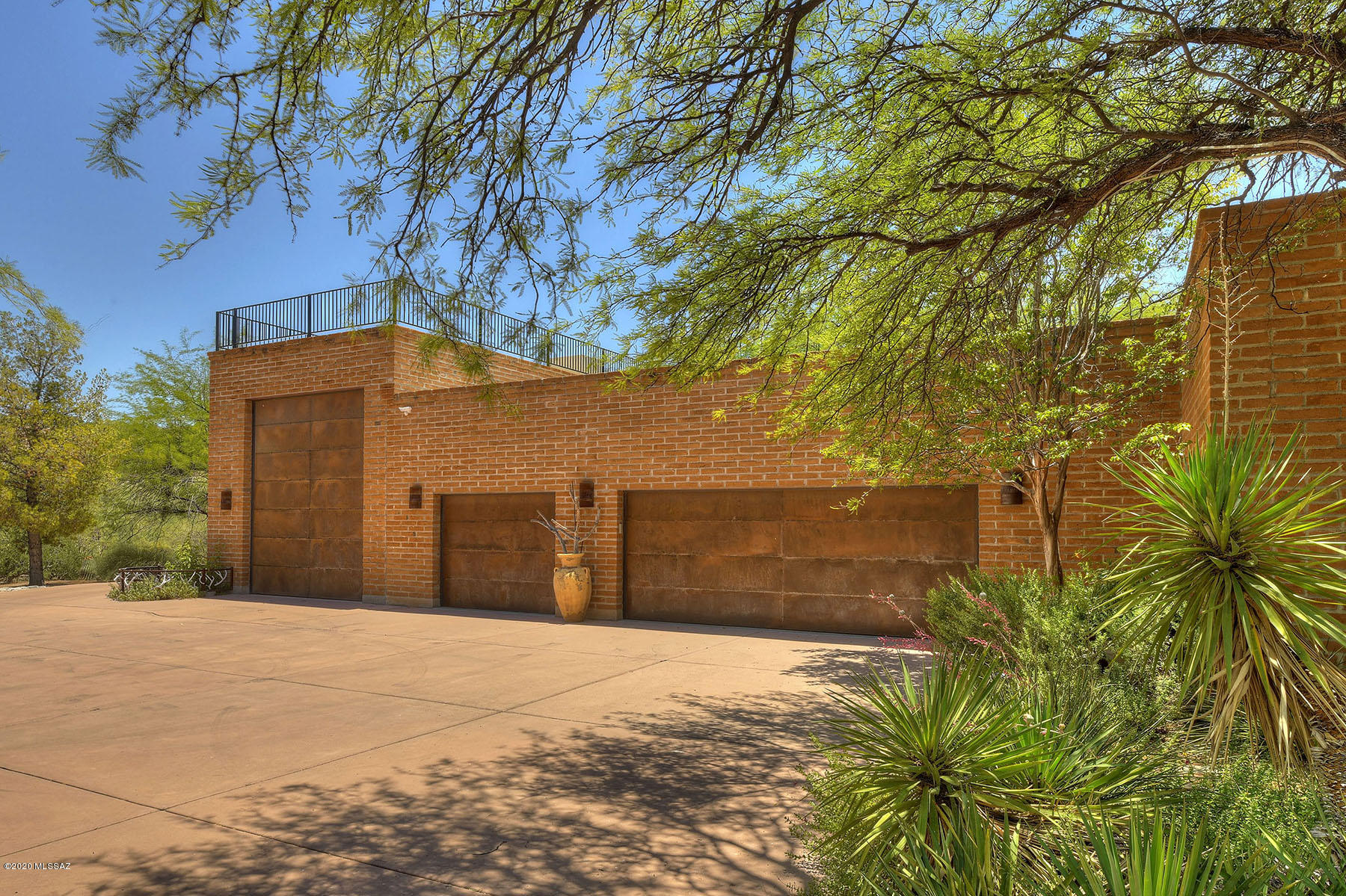 Exceptional Spanish Hacienda in a secluded Northside area. Long private driveway leads you to a Territorial Style burnt adobe masterpiece. Step in the courtyard thru authentic rustic gates & be surrounded by lush foliage. As you enter the home you are immediately struck by the inspiring setting & world class details. Attractive scored concrete flooring, beamed ceilings, working kitchen is a beauty in form & function featuring state of the art appl & concrete counters. Feel the warmth in the family rm w/masonry FP. Guests will enjoy the spacious split BR plan. Walls of windows & high ceilings make a bright & open feel. South facing backyard to experience year round entertaining w/refreshing pool, spa, water feature, outdoor kitchen & beehive FP. Generous 4 car garage w/multi-functional use