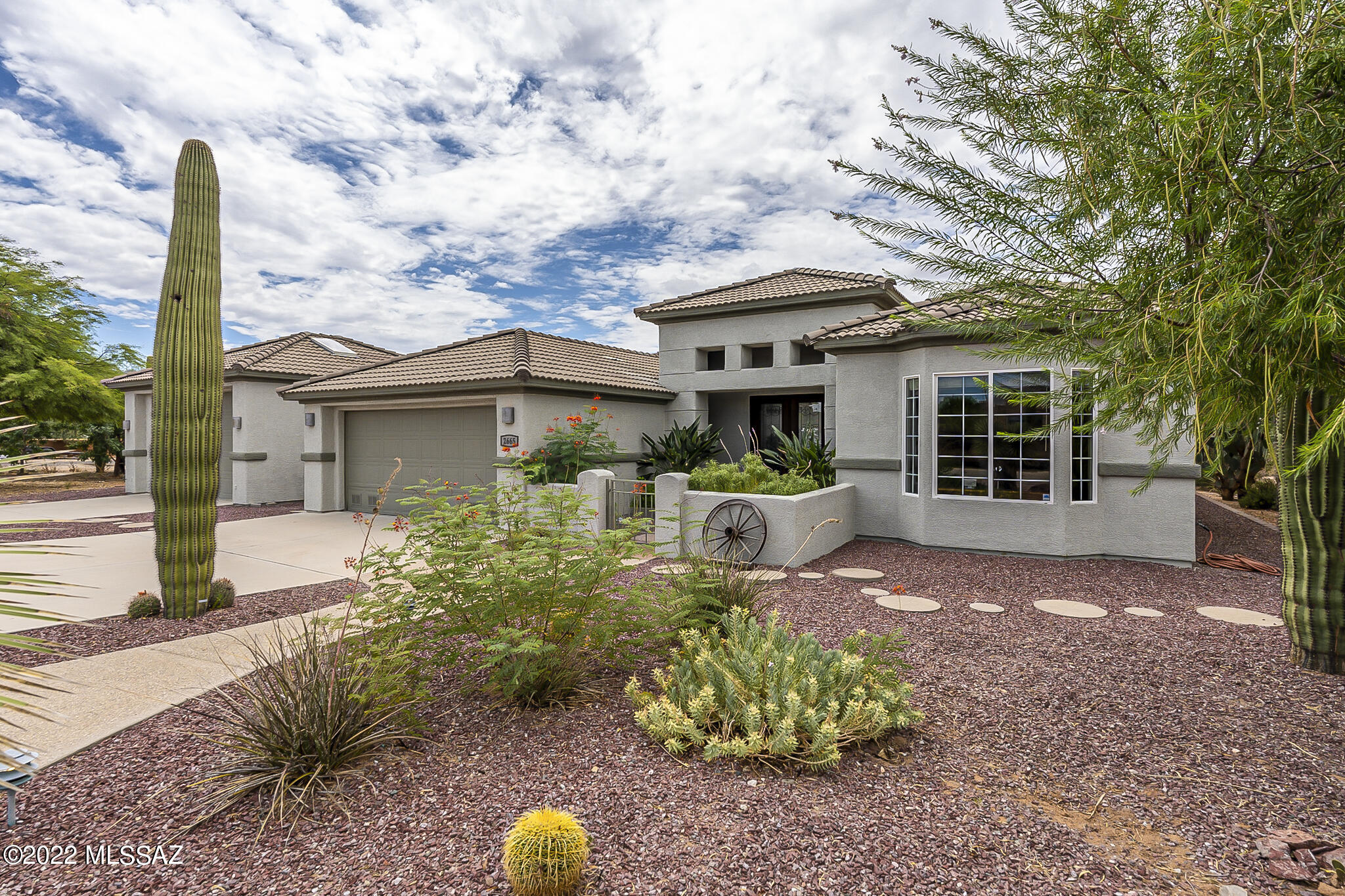 Take a look at this! A remarkable and contemporary custom-built, spacious home nestled on 1.12 acres with all the facets of country living possible yet within the city limits, and no HOA! Elegant porcelain glazed tile flooring greets you at the double door entry. Feel the quiet privacy of the roomy and inviting office/study, and two ample sized guest rooms with a joining bathroom. You really have to see this! The generously sized main bedroom features a gorgeous view of both mountain and desert with a separate entry to the covered patio and pool area. The kitchen is a perfect combination of functional and extravagant with handcrafted soft-close cabinets and drawers, ample granite counters, breakfast bar, dining room, and plenty of light... ...Beautiful scenic views of the mountains and natural desert landscape surround the entire property as you step outdoors to enjoy the pebble tec pool and landscaped back courtyard of citrus trees, walkways and luscious desert oasis, complete with a firepit with seating to enjoy the cooler Tucson nights. Relish your time in the delightful, covered atrium garden areas where multiple citrus trees and garden growing boxes can be found! The second detached two-car garage is ready for your workshop creations, with a 3/4 bathroom and climate control, or convert it into a guest house! Owned solar system with generator will keep you comfortable and keep the utility bills low! Live in the city and have your land too!