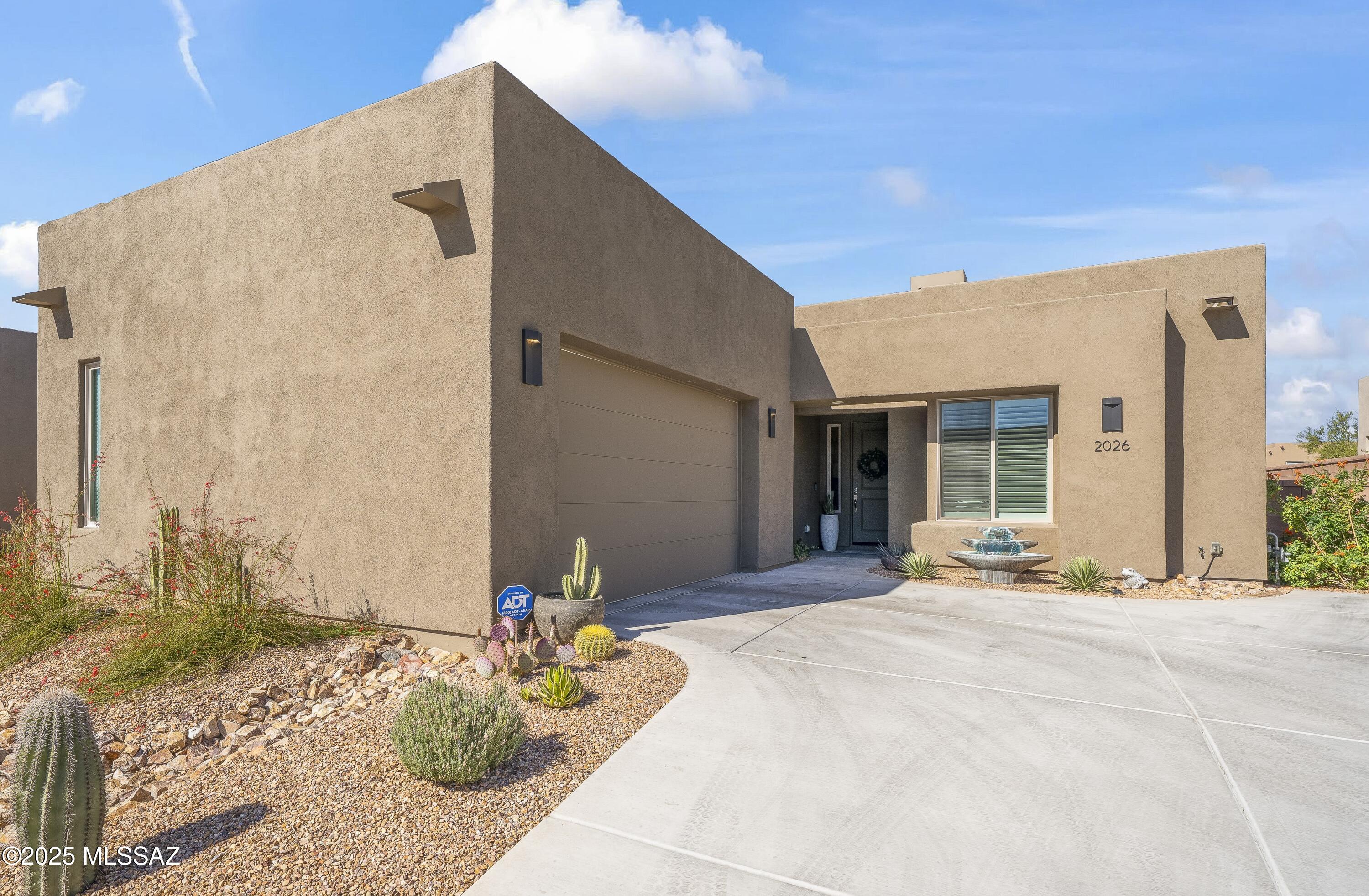 Enjoy modern desert living in this striking contemporary home, nestled in a gated commty of luxury hms designed by acclaimed architect Ron Robinette. The open grtrm features a dramatic floating drop ceiling, sleek tile FP, gorgeous chandeliers & designer flooring thruout. The gourmet kitchen impresses w/lg island, granite counters, SS appl &  abundant cabinetry. Spacious primary suite incl a walk-in closet, dual vanities, and a beautifully tiled walk-in shower. Custom shades thruout  incl plantation shutters in the addl bdrms. Beautifully curated landscaping w/a water fountain in front and back. Additional highlights incl 6-panel doors, elegant lighting & a block-walled bkyd w/turf, exposed wood beam covered patio w/new speakers installed and lovely mountain views to relax and enjoy.