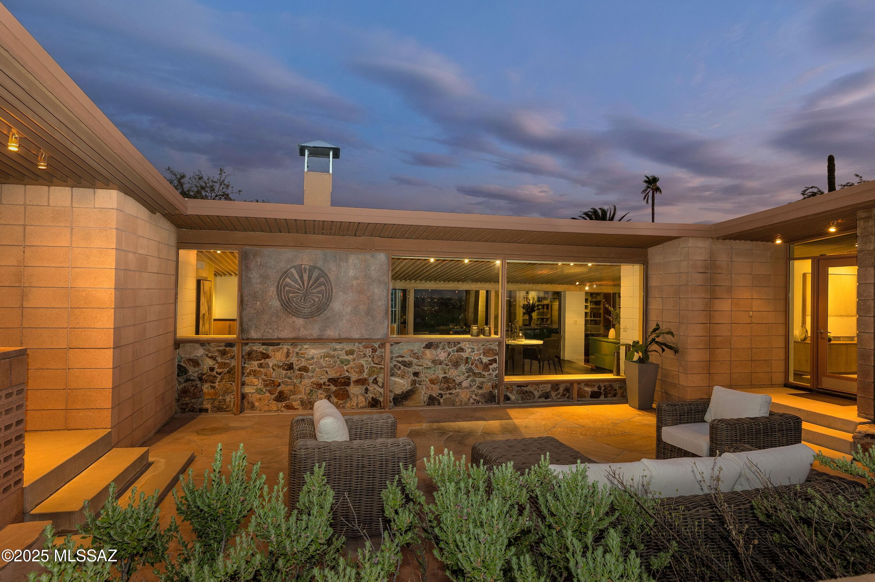 Where iconic modernist design meets the spirit of Tucson desert living. A stunning mid-century home built in 1958 designed by the distinguished architect, Nick Sakellar. Sited on 1.3 acre elevated lot w/ views from every room in the house. Last remodeled in 2000 & retaining its integrity. Gracious sized rooms & walls of glass protected by wonderful, deep covered patios. Unique open beamed ceilings throughout & a breathtaking stone wall & fireplace in the living room - a beautiful wall extending to the outside separated only by glass and enough built-in bookcases to make any bibliophile happy. Throughout the living area are rich, black slate floors. On cooler evenings you can dine on the covered patio overlooking the pool & city lights below or from the front courtyard you can enjoy watching  the mountains  turn  blue, pink & lavender as the sunset casts its light on the Catalinas. This is definitely a desert home to be lived in & loved; to entertain or to enjoy solitude and the quiet of the desert; for dining w/ friends or curling up with a wonderful book.
