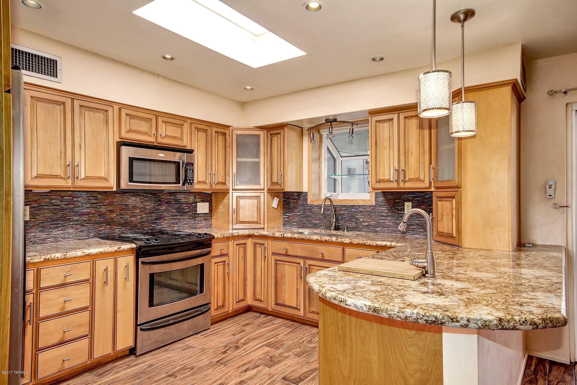 Seller will accept or counter offers between $105,000 and $115,000. This 55+ townhouse is a real gem. Beautiful upgraded kitchen has granite countertops w/glass tile backsplash, lots of newer cabinetry, SS appliances, vegetable sink, designer pendant lighting and many more details. Breakfast bar and dining area off the open kitchen. Gorgeous plank tile flooring. Updated baths w/travertine flooring and granite counters. Master bath features walk-in shower w/bench and slate surrounds and new cabinets w/pullouts. Newer A/C w/allergy filtration system. Roof recently re-coated. Whole house water filtration system. Non-VOC paints throughout. Storage/workshop area and separate laundry room. Lots of mature landscaping on drip system. Two-car carport. Private yard with covered patio and pavers.