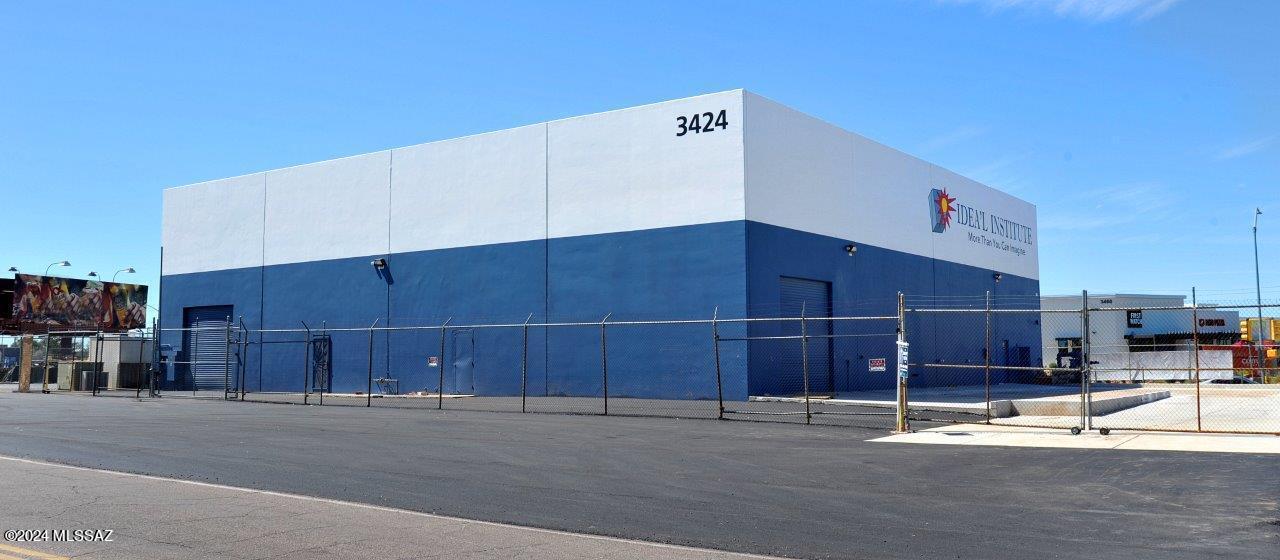Location, Location, Location.   This commercial building has it all.  Over 10,000 sq. ft of warehouse space with multiple roll up garage doors, concrete ramp and four bathrooms. There is also an additional 1500 sq. ft, 2 story office space consisting of 7 offices, training room, viewing room and air conditioning.  The over ½ acre lot is fenced with security fencing and has a newly paved parking lot.  
Located amongst the hottest growing sector in Tucson with many new restaurants, retail shops, hotels, Costco, Movie Theatre, Dave and Busters.  Only minutes to the Airport, I-10, Gem shows and the University of Arizona.
The building is also for lease for $12,500 a month, NNN.  Triple Net.  Seller is willing to carryback the loan depending on terms and conditions.