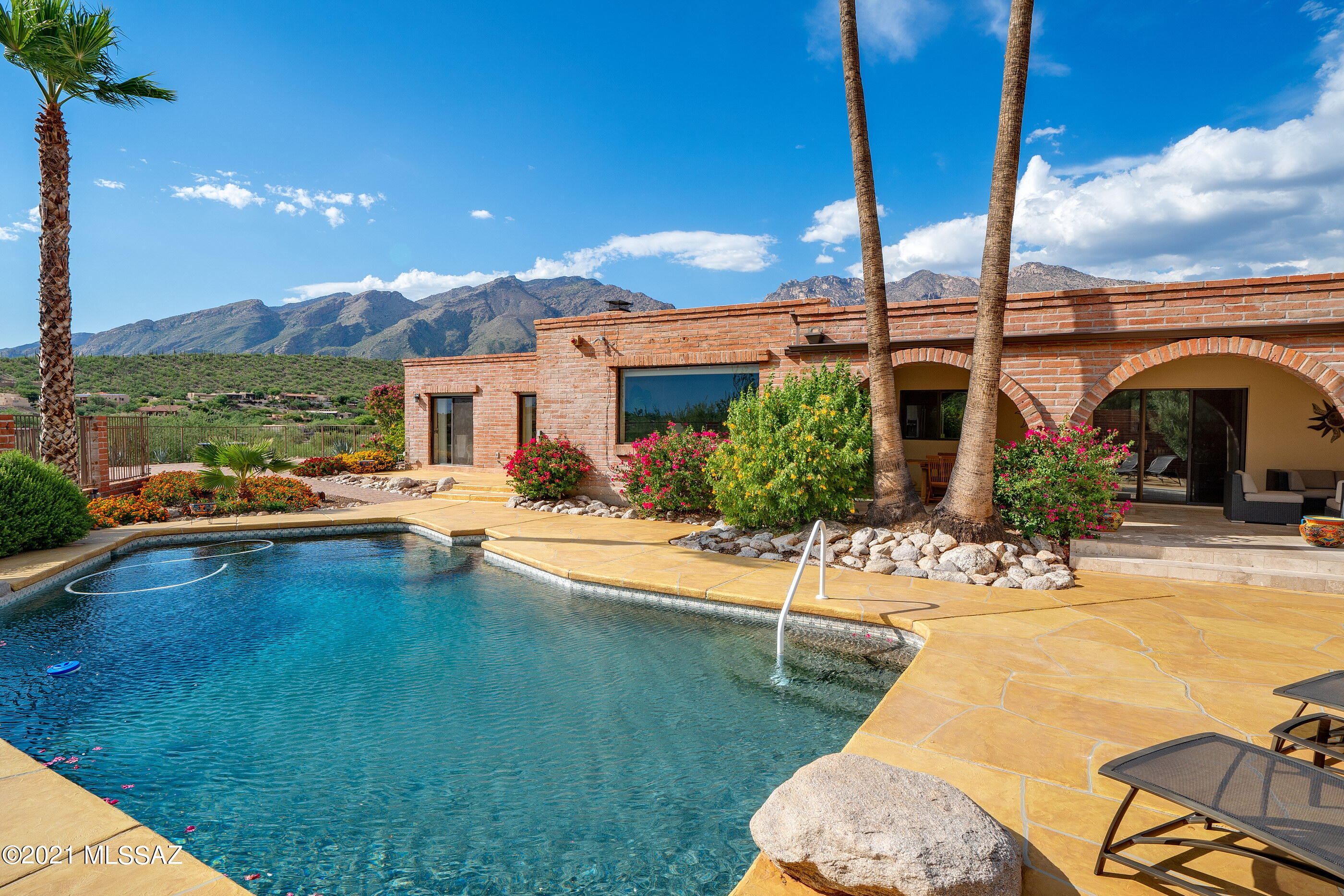 Located on a high view lot in Cimarron Foothills Estates, this classic, one-level burnt adobe home is completely remodeled & meticulously maintained. Panoramic mountain, city & sunset views from this very private near 1-acre lot.  Circular driveway lined in pavers complimented by low-care desert landscape. Bright & open split bedroom floor plan w/ travertine floors throughout (no carpet). Upon entry find the living room w/ spacious formal dining area. Updated kitchen w/ custom cabinets, granite counters & SS appliances opens to great room w/ high wood-beam ceilings & FP. Breakfast bar & breakfast nook provide informal dining.  Large pantry, bonus area w/ built-in desk & spacious laundry room. Exceptional deep covered patio off kitchen is perfect for entertaining groups lrg & small. CONT Spacious Owner Suite w/ Bee-Hive Fireplace & Charming Sitting Area w/ Beautiful Natural Light. Owner Suite Bathroom is Completely Remodeled w/ Dual Vanities, Custom Cabinets, Granite Counters, Clawfoot Tub & Separate Shower w/ Travertine Surround.  The 2 Additional Full Bathrooms are Updated Similar to Owner Suite Bath. 2 Additional Bedrooms both have Sliding Glass Doors to the Patio. Exceptional Backyard w/ Resurfaced Pool & Pool Deck, New Brick Paver Patio, New Pergola w/ Outdoor Kitchen that includes a Built-in BBQ & Refrigerator. 2- car Attached Garage & Oversized 2-car detached garage/workshop w/ wall AC Unit. This Extra Space Could be used in so Many Ways-Extra Storage, Workout Space, Art/Ceramics Studio or Whatever You May Need. Additional recently added features of this home include Plantation Shutters, Double Cherry Wood Front Doors, Irrigation System, Gutters, Soft Water System, Water Heater & Pool Pump, Filter and Motor.  District #16 Schools including Ventana Vista Elementary w/ Highly-Acclaimed Spanish Immersion Program. Incredible Foothills Location within Minutes of the Best Shopping & Restaurants Tucson has to Offer.  Close to World-Class Golf Resorts & Country Clubs and Tons of Hiking & Biking Trails including Sabino Canyon. This home is truly immaculate.
