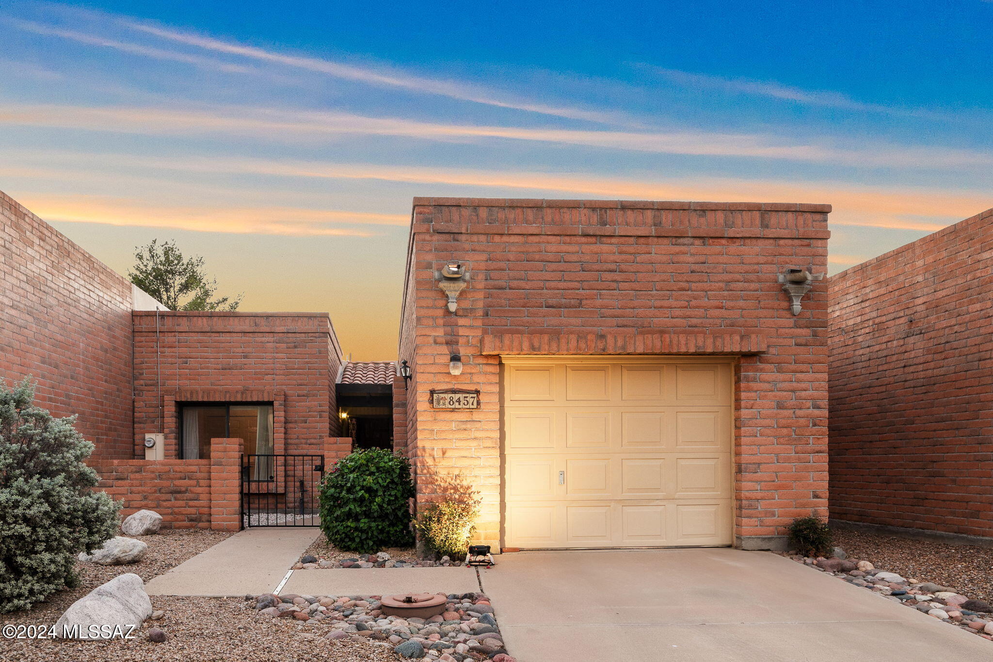 Delightful masonry territorial townhome located in Fairfield La Cholla Hills 55+ community. 2 bedrooms and 2 baths, generous living/dining areas. Sombrero Peak views. 16'' ceramic tile, hardwood and Pergo flooring~no carpet. Eat-in kitchen comes with SS appliances, newer cabinetry and convenient laundry closet. Cheerful primary bedroom w/private bathroom, tiled walk-in shower, walk-in closet. Step outside to a private walled yard w/brick pavers, orange and grapefruit trees. Sliding glass doors from living & primary bedroom open to private screened patio. Enjoy amenities, including pool, spa, tennis courts, pickleball, bocce ball and walking paths. Single car garage w/built-in storage cabinets. Roof recently double coated w/4 year no leak warranty. New water heater. No popcorn ceilings.