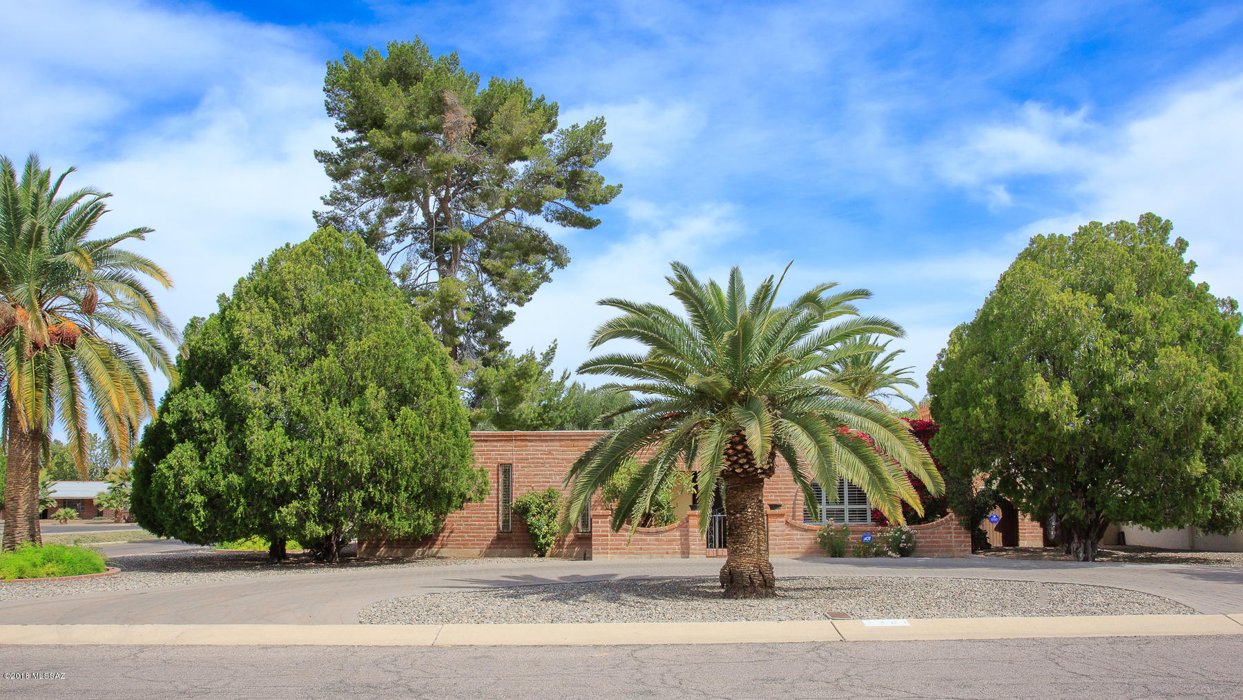 Lovely! This spacious 3 bedroom, 3 bath burnt adobe home in a dynamic central location sits on a HUGE (.30 acre) corner lot with a 2 car garage & tons  of built in storage. The large entry way welcomes you to the warm living room with an arched wood burning fireplace & window. Beautiful plantation shutters throughout much of the home. Three large bedrooms with lots of storage: 3 closets in the master & the other bedrooms have 2 closets each. Expansive covered patio faces north which opens to a lovely back yard with mature & beautiful foliage including the wall of jasmine! Perfect space for entertaining & hosting! Glenn East is wonderfully situated near the Campbell Avenue corridor & is within walking distance to parks, shopping & dining, bike routes, transit, UA, UAMC, etc.BikeScore of 94!