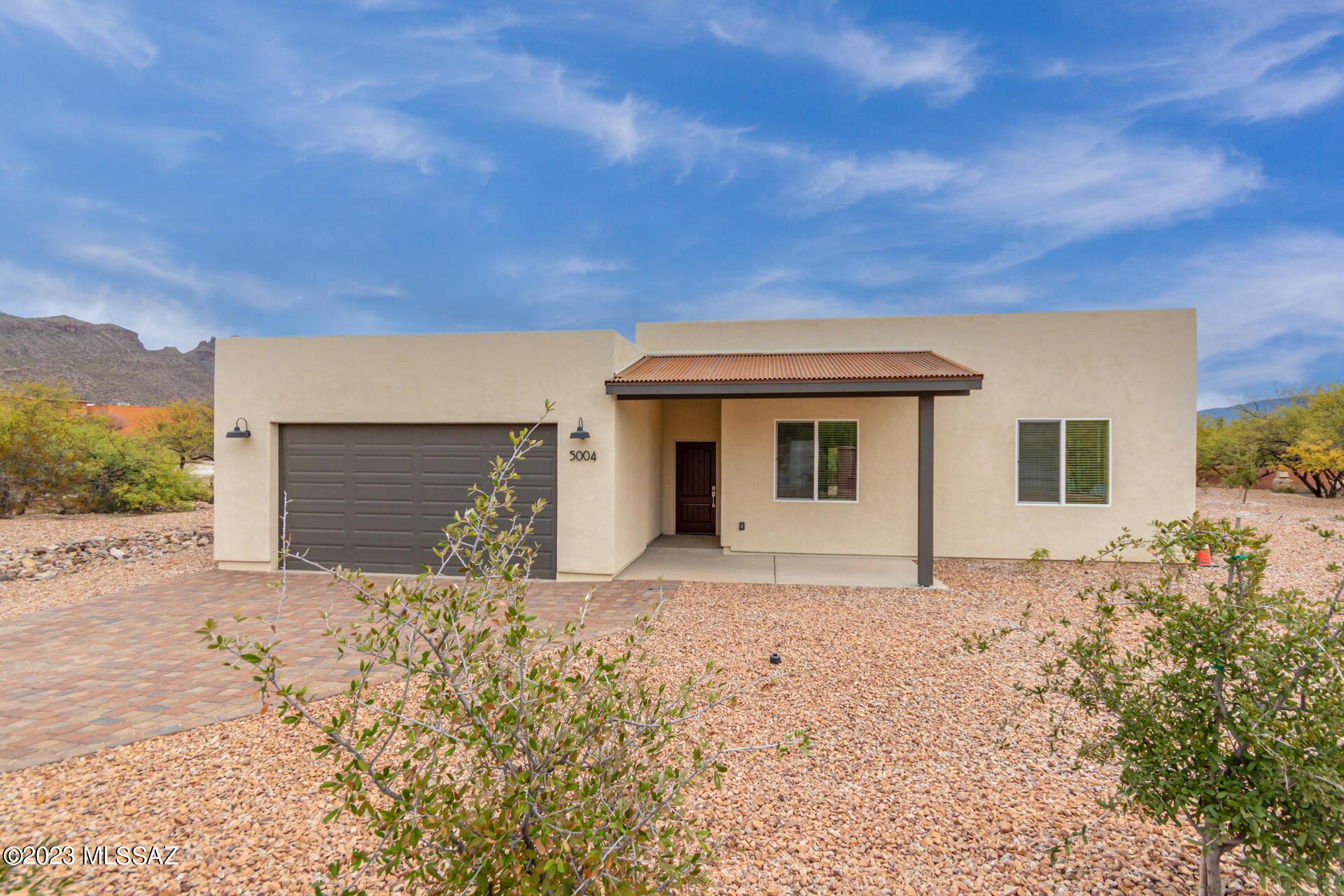 Paver driveway and window treatments have been installed. Gorgeous NEW home plus detached guest house on nearly 1-acre in Hidden Valley, complete with a 2-year builder warranty. Main home features 4-beds and 2.5-bath while the guest home includes 2-bed, 1-bath, full kitchen and laundry. This remarkable Santa Fe style residence features a spacious 2-car garage, a desert landscape, and a covered front porch. The perfectly planned interior boasts an expansive open floor plan reflecting a contemporary aesthetic w/high-end finish that include luxury wood-plank tile flooring, neutral palette, high ceilings, and recessed lighting. The bright & light areas seamlessly connect, providing the ideal setting for entertaining. The impeccable kitchen showcases elegance & style with its grey cabinetry, marble-like tile backsplash, SS appliances, granite countertops, and large island! The primary suite offers a sizable walk-in closet & a lavish ensuite w/dual vanities, granite counters, a soaking tub, and a step-in shower. You'll also find a convenient Jack & Jill Bathroom with the same details as the primary ensuite. The backyard has a covered patio, which is excellent for relaxing after a long day. Crafted to perfection, this beauty combines modern design & high-end finishes to create a stylish and functional home. All appliances have an extended warranty for a total of 6 years coverage. Must see!