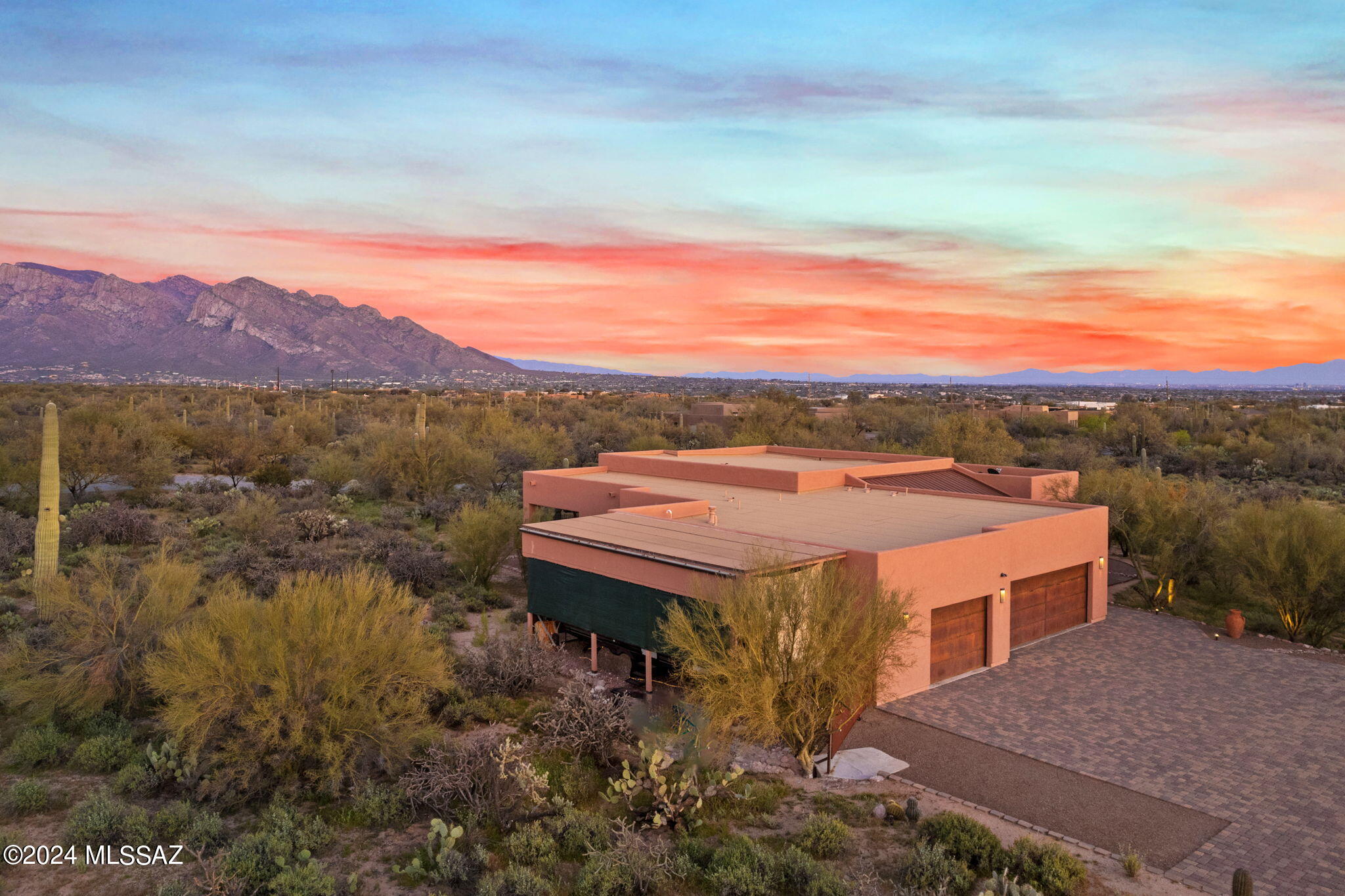 Exquisite CUSTOM LUXURY ESTATE situated on 3.3 acres in a small, gated enclave of only 3 homes boasts East facing Catalina mountain views, 3 outdoor patios, energy efficiency and NO HOA! This elegant contractor's private residence is situated within a pristine desert setting and lies just beyond a private roundabout at end of road affording ultimate privacy and serene views. Greeted by a brick paver driveway and paver courtyard with rustic iron gate, enter to find a large open-concept floor plan featuring formal living room with impressive media wall, 5.1 surround sound, picture windows with remote shades plus stellar mountain views. Gather in the well-appointed gourmet kitchen with pendant and recessed lighting, wraparound island with breakfast bar, sleek granite countertops with tiled backsplash, stainless steel appliances including double in-wall ovens, microwave, gas cooktop with exhaust hood, dishwasher and side-by-side refrigerator. Adjacent open dining area flows to family room off main patio highlighted by a cozy Heatilater gas fireplace with floor-to-ceiling stacked stone surround and hand carved Alligator Juniper wood mantel. Retreat to the elegant Owner's suite with private outdoor patio hosting a relaxing spa/hot tub to unwind at the end of the day. Luxurious spa bath boasts split dual vanities with marble countertops, a unique soaking tub with Travertine tile surround, walk-in Travertine tiled shower and divided his/hers walk-in closet. Guest wing houses two additional en suite bedrooms, each accessing a private vanity and walk-in closet and sharing a central tiled tub/shower enclosed by pocket doors for privacy. Sleek powder room displays a marble top vanity with vessel sink and stacked stone wall. Laundry room off garage hosts plenty of storage cabinets and workspace. Relax or entertain on the main rear patio with inset wall-to-wall BBQ station while overlooking a decorative, carefree turf lawn plus natural desert, mountain and sunset views. Thoughtful amenities throughout this home include custom Alder cabinets and doors, gorgeous engineered wood flooring, custom window coverings, fire suppression system and central vacuum. Additional amenities include wood shutters, insulated interior bathroom walls, insulated 3-car garage with enclosed third bay, upgraded roof and newer exterior paint. This spectacular property is also plumbed for gray water and includes a covered parking space for your boat or recreational vehicle. A true gem in the desert yet close to all amenities including parks, hiking/biking trails, golf, shopping, dining and entertainment. Perfect for the most discerning buyer!