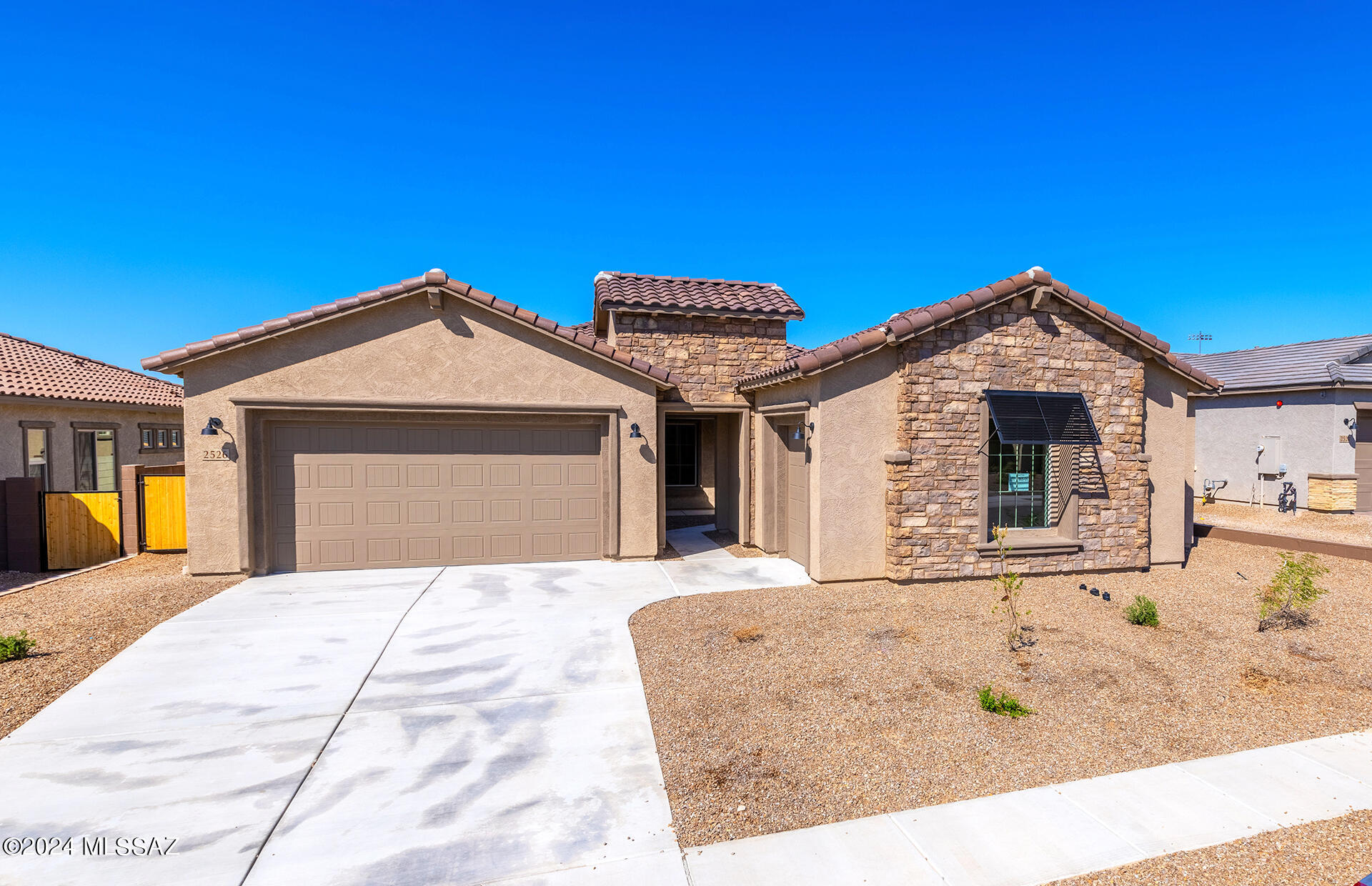Move-in ready. This stunning 3,241 sq. ft. home in Oro Valley, located near the end of a cul-de-sac, features an elegant stone facade and inviting front courtyard. The spacious interior includes a grand gathering room with a 4-panel sliding glass door and a gourmet kitchen with top-tier KitchenAid appliances, pull-out cabinets, and soft-close features. The private suite in Bedroom 5 and the versatile flex room offer tailored living options. Upgraded electrical, a tankless water heater, and pre-plumbed laundry sink complete this exceptional home.