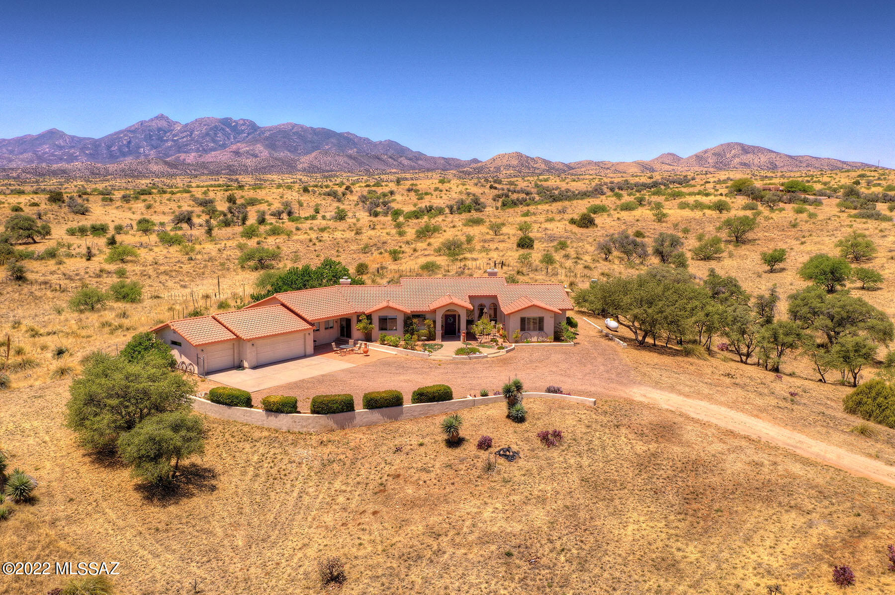 Perched against the Coronado National Forest Boundary, abutting the Santa Cruz Mountains, this spectacular home situated on 13.3 scenic acres, awaits you. Million dollar unobstructed views abounding with wildlife and natural habitat give unparalleled privacy.  This well designed, spacious Spanish mission style home rests embedded in the gated Sonoita subdivision of Singing Valley South with its own lockable gated entry and private well.  The property is fully secured. A beloved hummingbird oasis has been lovingly nurtured by current owner.  A sanctuary to behold with convenience to Tucson.