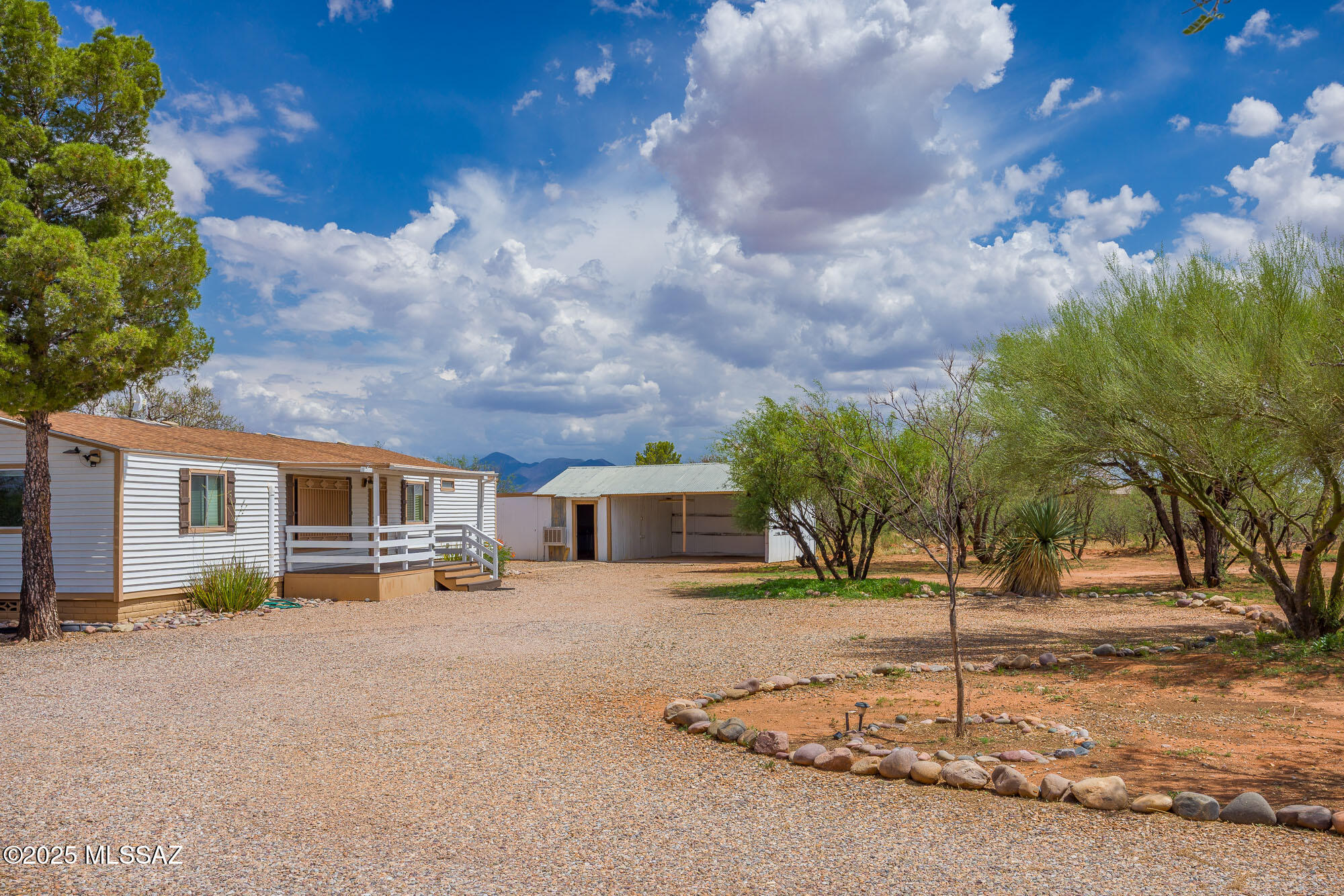 Public Remarks: Welcome to your peaceful retreat! This spacious 4-bedroom, 2-bathroom manufactured home sits on 3.97 fully fenced acres and offers breathtaking sunrises and sunsets from both the front and back covered patios. Inside, you'll find two inviting living areas, rustic-style flooring, and a warm, quiet atmosphere throughout. The property features a charming gazebo, multiple storage sheds, and a large workshop with A/C and a two-car carport. Additional highlights include an electronic gated entry, beautifully landscaped grounds, paved road access, a dedicated laundry room, block skirting, and mini-split systems throughout the home for year-round comfort. This is country living at its finest—relax, unwind, and make it yours!