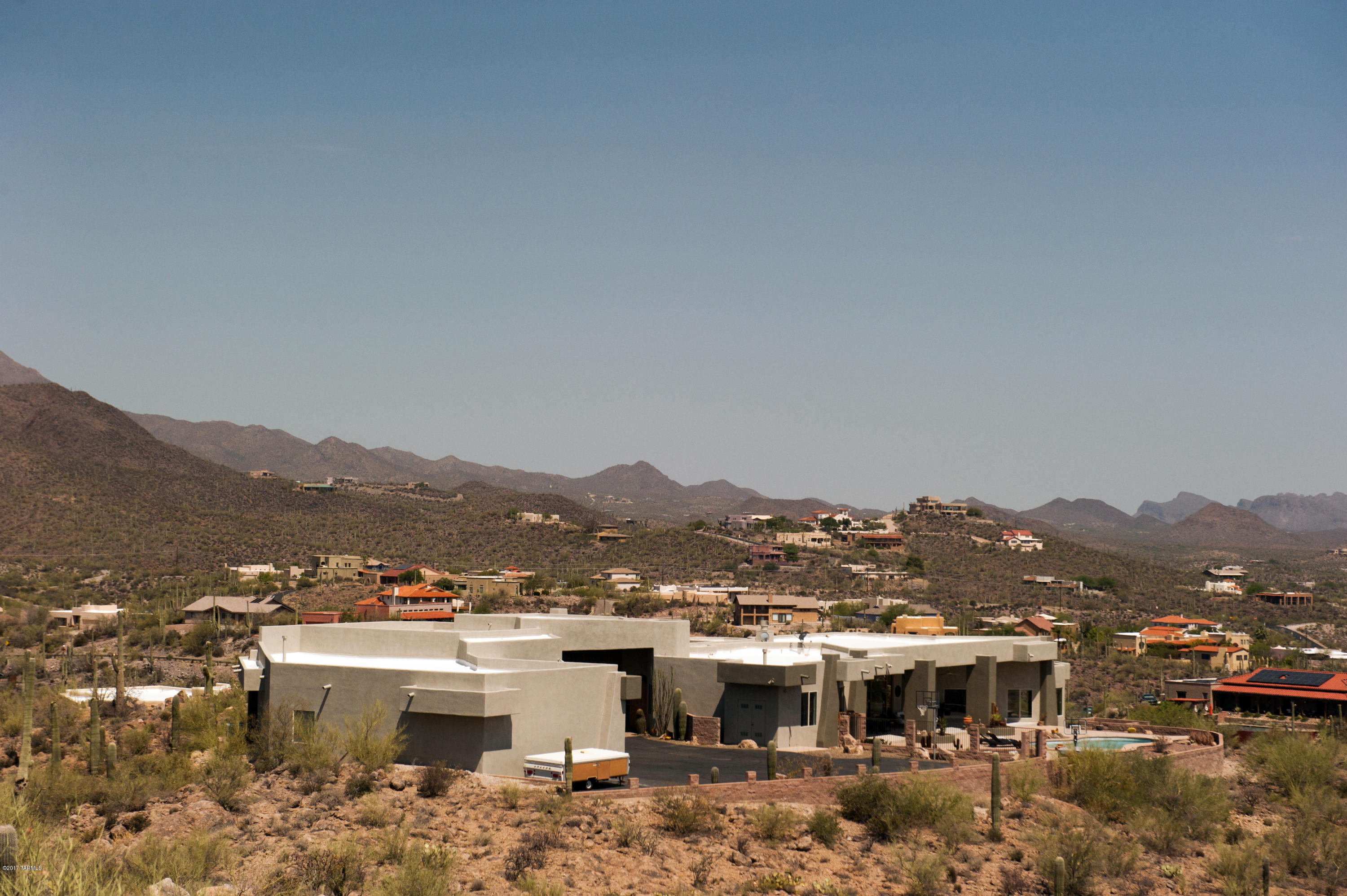 Custom built home in the foothills of the Tucson Mountains on 5 acres. Spectacular views of the city and the Mountains. Private drive to the house is lined with an abundance of saguaro cactus. The driveway enters the property through a breezeway, which opens up to a spacious auto court for plenty of parking for your guests and RV. Open floor plan and multiple bedrooms with adjoining bathrooms so you do not have to share. Huge 6-car garage with a workout room, indoor parking for all your toys, storage for Holiday decorations, air conditioned and heated for all year use.  Easy access to I-10. Huge covered back porch for out door living and just relaxing while enjoying the view of the city coming alive at night. This house is a must if you have a large family and like to play hard and relax. Great views from the pool and spa, you will never want to get out. If you do not say "Wow "the moment you drive into the auto court then this house is not for you.