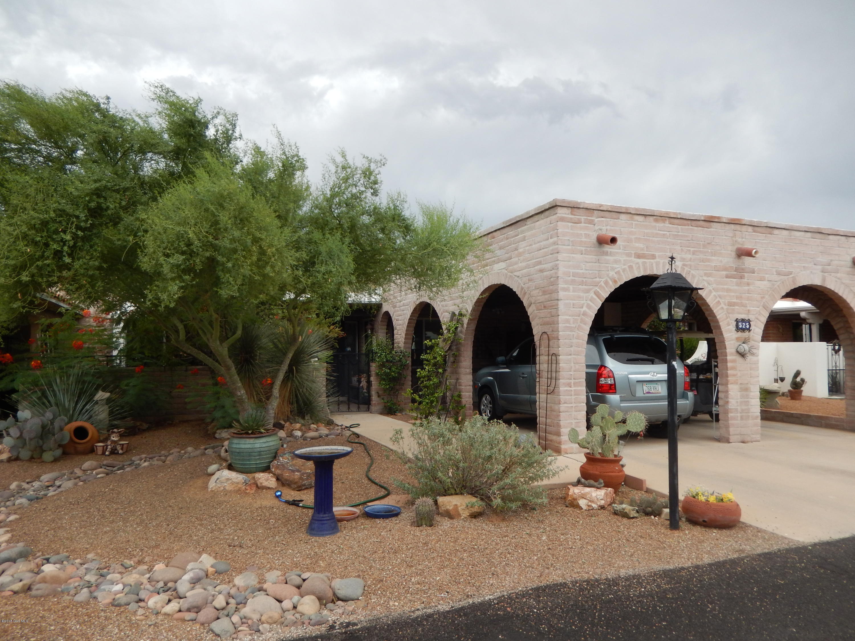 You've found your Oasis in the desert! Enjoy the lush setting and updated conveniences. 2 Bedroom suites, 2 Baths, plus den/family room, large living room, & screened back porch. Cozy gas beehive fireplace and lovely tile floors. The kitchen boasts stainless appliances, corian counters, and glass tile backsplash. Built-in cabinets with desk, extra hall storage and carport cabinets. Other features include roller shutters, pull out shelves, & 14 seer AC. Extra long 2-car carport but could make house dark if converted to garage. Some furniture available by SBOS