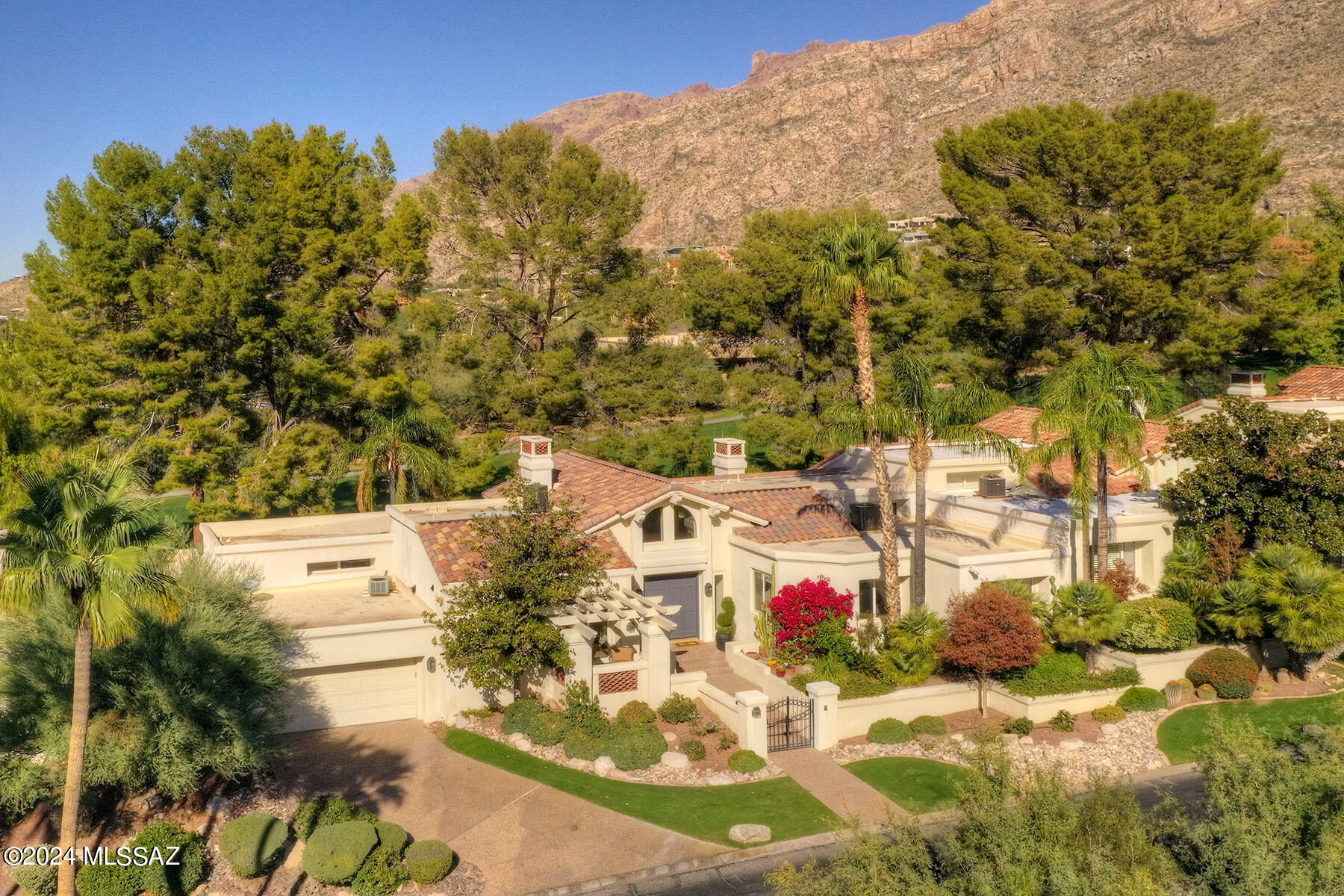 A tree lined drive winds up to this stunning Santa Barbara styled Luxury Home located within one of Tucson's premier Guard Gated Communities, Skyline CC.  Whether you're entertaining or enjoying peaceful living, it's made easy with over 3000 sq ft in this 4BR / 4BA Single Story Home.  Combining exquisite finishes with a Practical Floor Plan, you walk into a Meticulously Designed Home with its Wall of Oversized Windows / Patio Doors to create the ambiance of Light Soaring, with 20 ft High Ceilings, setting the stage for Luxury Living throughout. Gorgeous Kitchen-Family Rm with Expansive White Quartz-top Island, Knotty Alder Cabinetry. SubZero Frig &  Bosch Appliances, and Walk-in Pantry.
A Luxurious Master Bedroom Suite with Fireplace and Romantic Patio is the perfect place to begin and end each day.  Spacious Master Bathroom with Walk-in Shower and Garden Tub crowned with a Tasteful Chandelier.  Plus this home has a second ensuite bedroom and bath perfect for guest/mother-in-law etc.  Unparalleled Quality and Craftsmanship throughout plus the Soaring Views of the Catalina Mountains can be viewed across the home or on your Resort Sized Patio Setting, on the lush Skylline CC Golf course! Red Chandelier in Dining Rm does not convey.

Skyline Country Club will cater to your passions, with over 3 miles of walking trails to discover with your friends, a complete fitness center, driving range and dining privileges available to all homeowners.  You'll absolutely love living here!