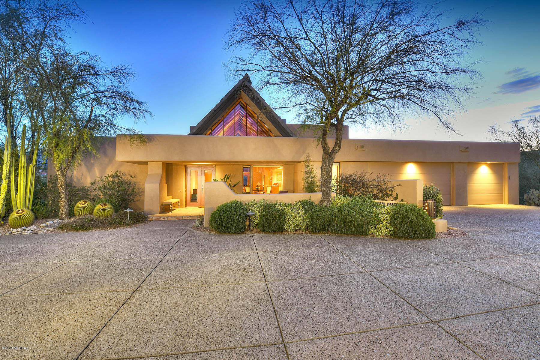 Remarkable southwest contemporary Tyson Murphy design in prestigious gated Village on Hacienda Del Sol subdivision. Live comfortably and entertain lavishly with walls of windows that showcase spectacular mountain vistas. Formal living features cathedral wood beamed ceiling & cozy fireplace. Generous kitchen with granite, some newer appliances & prep sink open to family room & large eat-in area. Light filled Master suite with jacuzzi tub, spacious tiled shower & walk-in closet. True to design are en-suite guest bedrooms w/spacious walk-in closets. Enjoy the surround sound throughout & newer exterior paint. Easy care landscaped yard with new BBQ. One acre elevated cul-de-sac lot with stunning views! One owner well loved & maintained home.
