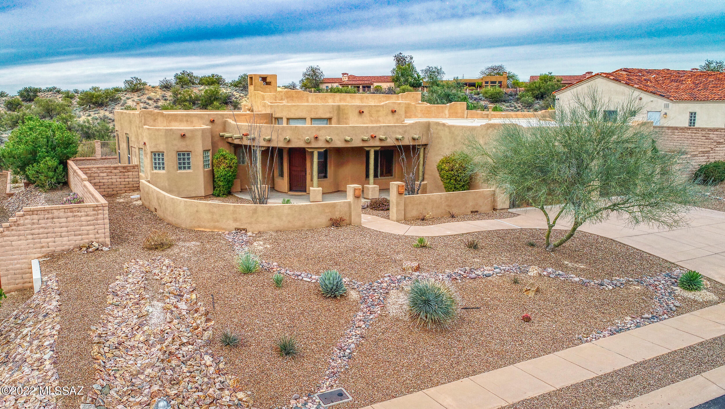 This beautiful Sombra built home is located in the gated community of Pusch Ridge Vistas II on a quiet cul-de-sac street. The home rests on a private, elevated lot with no neighbors behind & amazing views. Upon entering the home, you are greeted with soaring ceilings, tons of natural light & large windows. Split bedroom plan. Master bedroom has its own fireplace. Kitchen is a chef's and entertainer's delight. Equipped with double ovens, gas cooktop, granite counters and plenty of cabinet space. Kitchen opens up to the spacious great room with gas fireplace. Versatile room (den, formal dining, etc) is detailed with Viga beams and wood ceilings. Step outside to a yard big enough for anything you can imagine. Enjoy the peace and quiet, the privacy, and the view.  Relax outside all year long.