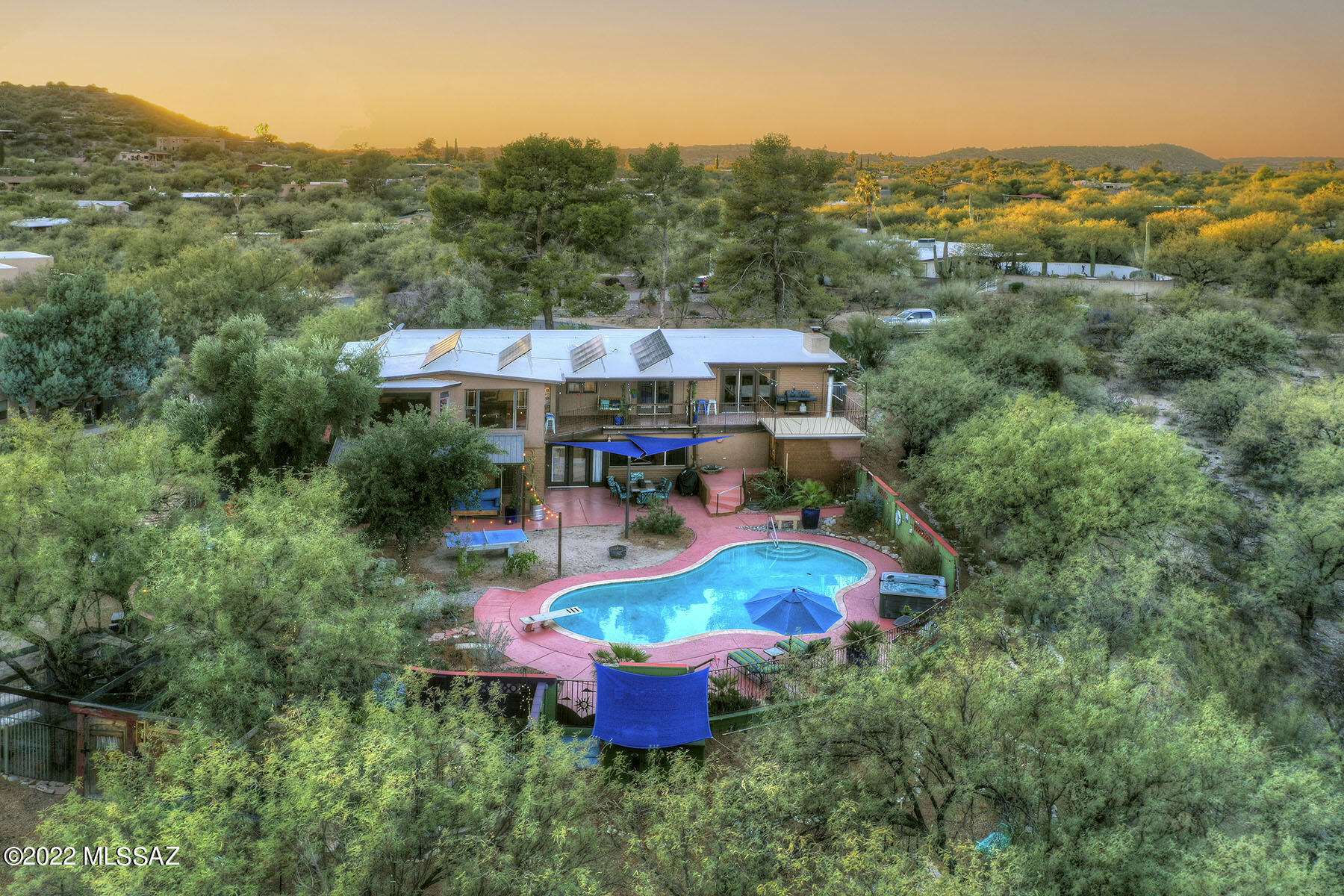 Rare Hidden Valley Gem!  Located in one of the most magical settings in Tucson, along a private 12 ac riparian habitat of Sabino Creek.  This enchanting home & guest home enjoys an organic orchard, gardens, chickens & the charm of the Old Pueblo. If you love nature, hiking, birding & amazing views of the Santa Catalina & Rincon mountain ranges this home is for you! The main house is 2599 sq ft and is on the upper level & includes a large living room & a wood burning FP & dining area. Large kitchen opens to the dining area & familyrm. The primary bedroom is separate from the 2nd & 3rd bedroom. The bathroom that serves the primary bedroom has Talavera sinks & Mexican tile accents. Downstairs has a large 1228 sq ft guest home that is a working AirBNB & has a separate courtyard entrance.
