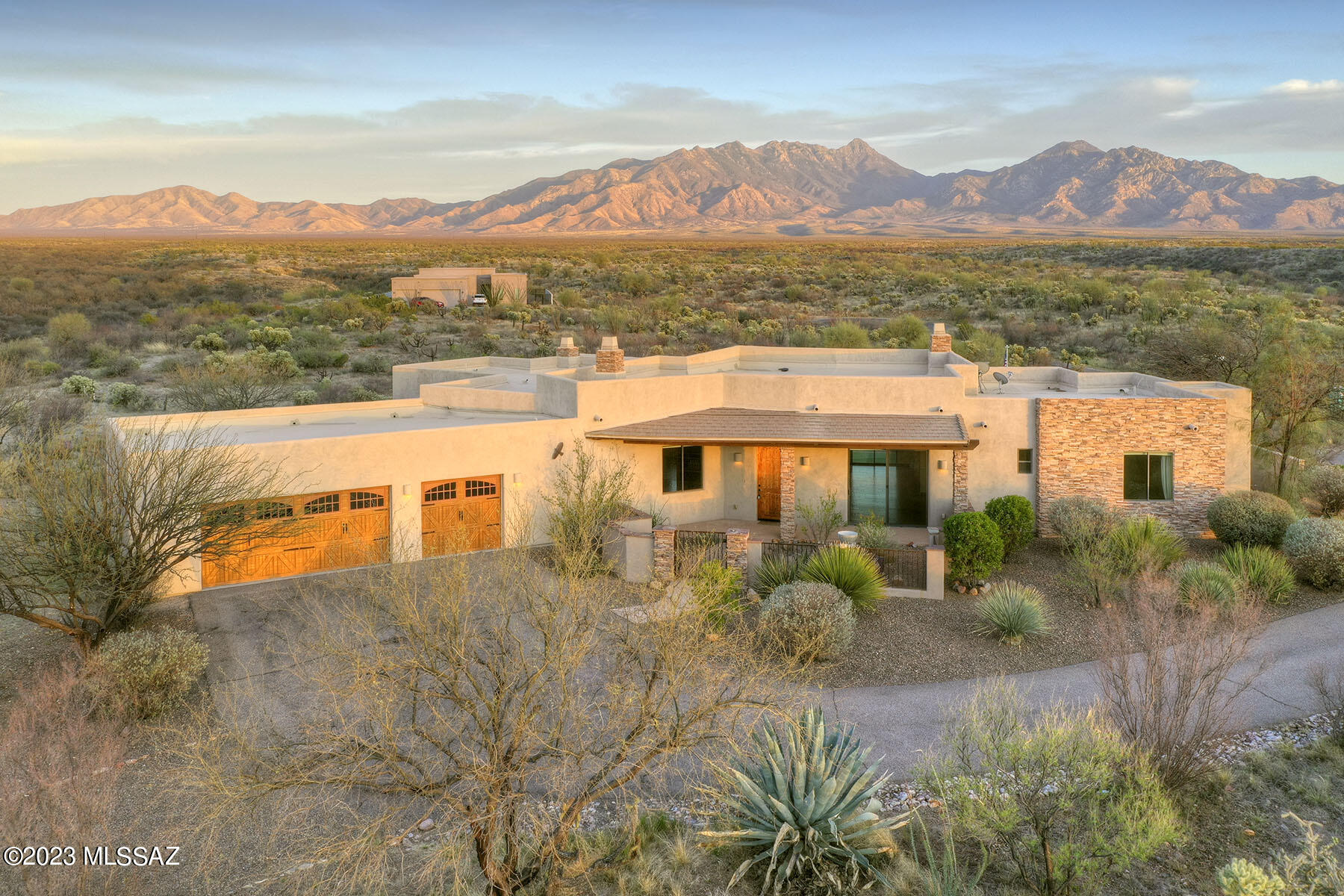 Sitting high on a hill on 1.62 acres this 2992 sq. ft. custom home offers the ultimate in privacy and luxurious living, in addition to  spectacular, unobstructed Santa Rita Mountain VIEWS!  An impressive, grand drive leads up to the oversized three car garage and the large front courtyard.  Stacked stone pillars give a hint of the luxurious touches inside.  Gorgeous 8' Alder wood doors with matching Alder cabinetry throughout the home add sophistication and limestone & tile in the baths add an organic feel. 3 fireplaces with stacked stone surrounds anchor the family room, living room and owner's suite. Soaring ceilings add spaciousness and light.   Multiple, versatile living spaces offer unlimited entertaining options for your dining, family and living rooms.  A sparkling pebble tech pool