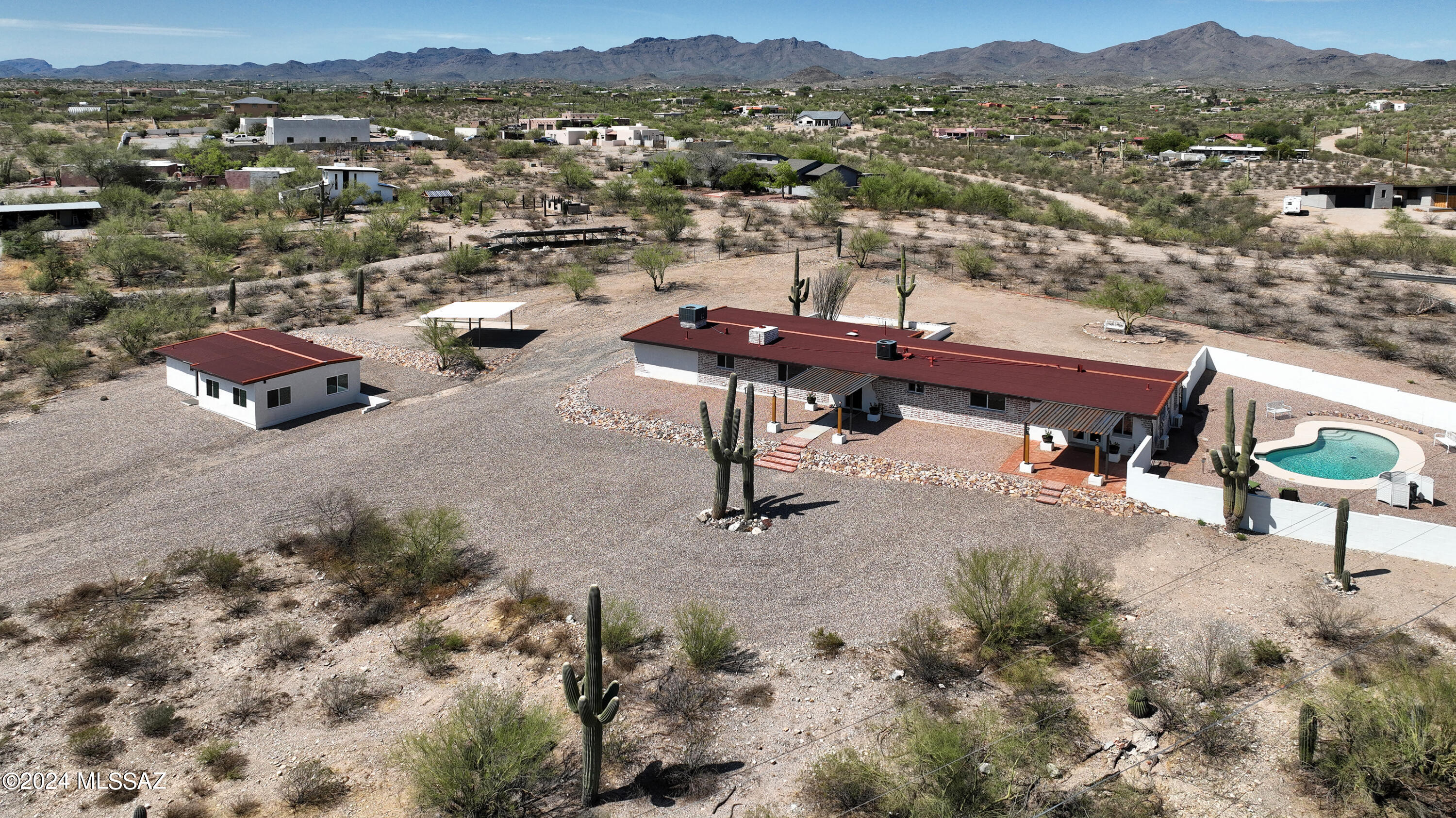 This expansive property is truly the ultimate in multi-generational living, and also has the potential to be a lucrative investment as a vacation, long term, or multi-family rental! Don't need a guest house? Live in the main home, and rent out the Casita to help pay the mortgage or for extra income! Sitting on almost 4 acres of pristine Sonoran Desert, this is your private sanctuary from the world, offering panoramic views of several mountain ranges & twinkling city lights from each & every one of the new (low-E) windows, not to mention the unparalleled AZ sunsets you'll enjoy while relaxing in the pool!  Beautifully, thoughtfully, renovated and restored Classic Burnt Adobe Ranch home, brimming with character and rustic charm, updated with modern amenities. Over 2400 SF of living space in the main home (5 bedrooms, 4 bathrooms, & 2 kitchens including the ''Mother-In Law'' wing) and a 700 SF separate Guest House Casita, boasting a chef's dream kitchen, views from every window, 1 bedroom and 1 bath. There's even a large RV pad for your Tiny Home or Winter guests, as well as a 2-car Carport, and plenty of land to build the garage or shop of your dreams!
This charming desert ranch home has just undergone a massive renovation that took over 7 months to complete. Here are just a few; in a long list, of recent upgrades/updates:

Re-pipe in/out of main home and guest house with warranty
New roofs with warranty
3 New Mini Splits with warranty
2 Newer HVAC's on main home are serviced w/new ductwork
New Low-E windows, new doors, hardware, etc.
All new High-End appliances in both homes, all 3 kitchens w/large capacity fridge and custom Verona Italian Range in main kitchen
All new stained concrete overlay flooring throughout- NO carpet!
New vanities, water heaters, plumbing, toilets and fixtures
All new granite just installed by "Granite Kitchen and Bath" on custom cabinetry in all 3 kitchens
Classic Burnt Adobe preserved, while adding to the rustic charm with custom mortar wash inside and out, along with synthetic stucco for longevity.
New paint throughout both homes (Dunn Edward's Everest ZERO VOC)
New pool plaster, tile, Auto-Fill, Block Walls, etc.
Extensive grading, landscaping and rock work with Over 400 TONS of gravel and decorative rock.
Two Bay Carport

Receipts/warranty information will be provided on HVAC, Plumbing Re-pipe, Roof, etc, along with ROC Contractor license numbers and info.

Bring your friends, family, extended family, or rent all of the extra space for additional income! Prime location on Tucson's sought-after West side, less than 2 miles from I-10 for an easy commute to anywhere from Caterpillar to Raytheon, and 3 miles from award-winning Lehman Academy, close to shopping, medical, golf, and some of the best dining Tucson has to offer. With a total of 3 kitchens, 6 bedrooms, 5 baths, NO HOA, Solid, Burnt Adobe construction, hill-top views, room for all of your toys and even your horses, this is truly a rare find! Come and see all the possibilities this property has to offer!