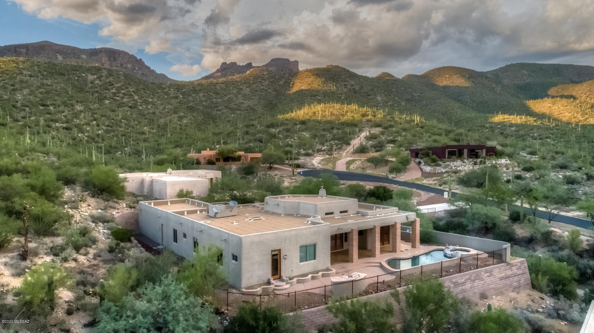 Stunning home bordering National Forest with unbelievable city & mountain views. Gated Community.  Perfect split floor plan w/ 5 bedrooms, 3.5 bathrooms, and a 3 car garage. Guest quarters has their own bedroom, bathroom, pocket door for privacy, & own entrance to backyard. Completely private backyard with Pebble Tec self cleaning pool & spa that overlook one of the best views in Tucson. Huge covered patio is perfect for entertaining. Gourmet kitchen with granite countertops, stainless steel appliances, island, custom backsplash, & gas range. Travertine floors throughout, Climate controlled 500 bottle wine cabinet, 15' high ceilings in great room, & gorgeous custm iron & glass entry door. This home is the perfect total package. Move in ready & absolutely perfect. Slr is licensed AZ Realtor