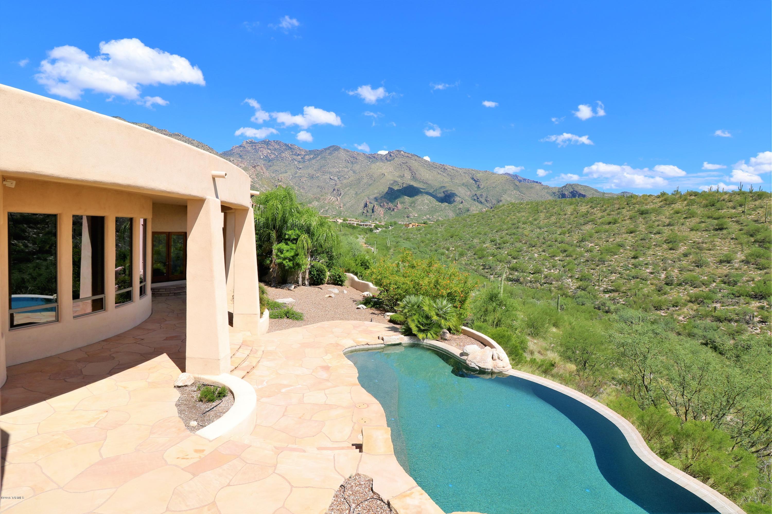 Completely private hilltop home in Catalina Foothills! Designed by renowned architect Paul Rondelli this custom home has breathtaking mountain and city views from every window! Gourmet kitchen is a chef's dream with top-of-the-line stainless steel appliances including a 5 burner Dacor stove, double convection ovens and 2 dishwashers. Travertine tile throughout the home. Built in wet bar with wine refrigerator!  Spacious bedrooms feature built in shelving. Enormous custom closet in master. Spa-like masterbath with double vanity, step down soaker tub and separate water closet. Enjoy your own private view of the Catalinas from your pebble-tec pool and spa. Please stop by to tour the home Saturday 10/8 from 11-3! This is a must see designer home in an exclusive foothills community!