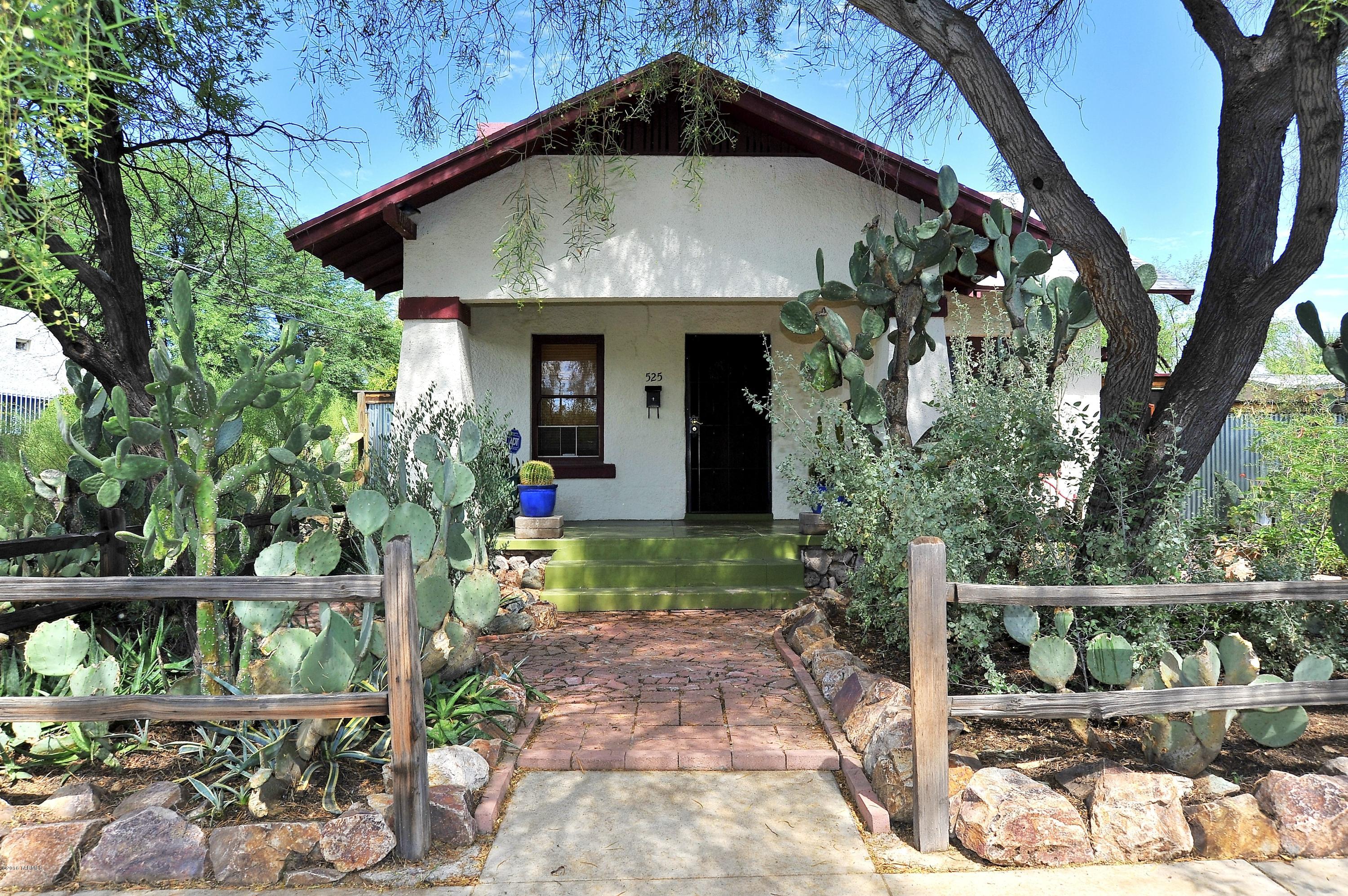 Central Bungalow full of Charm!!  Incredible curb appeal with native landscaping and mosaic brick walkways throughout front and back yards. This restored Craftsman Period Bungalow offers earthy color and materials such as hardwood flooring, built ins throughout, custom stained glass windows and detailed wood trim around door frames and window sills. Home features 2BR’s plus double French doors leading to a 3rd BR, or can be used as a studio or den! Wonderful living room has ceiling fan and a wood burning fireplace with built in shelving on both sides. Bathroom is detailed with wood trim, claw foot tub & Period fitting hardware and faucets. Located on a double lot WITH a garage completely fenced backyard with a sliding gate! Minutes to the UofA, UMC, shopping & dining!