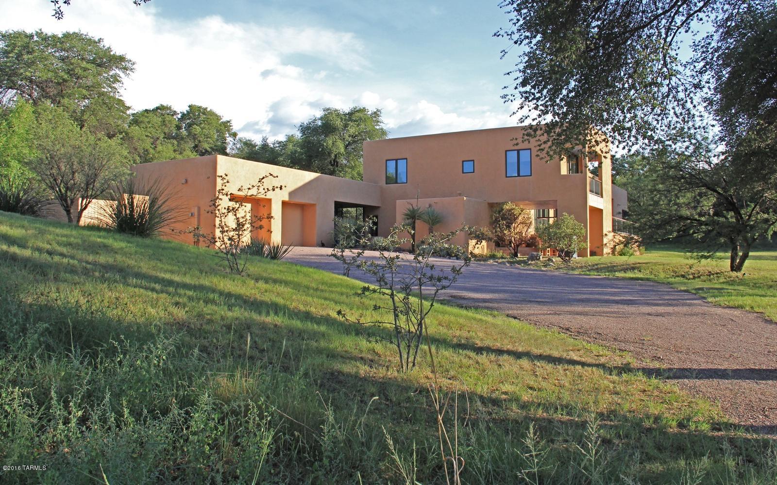 Spectacular Country Estate on almost 80 acres with no HOA! Southwestern Contemporary home designed by noted architect Bill Cook, with high ceilings, floor to ceiling glass Pella windows to capture the stunning pastoral views, and outdoor living areas on 3 sides. The land is exquisite grasslands mixed with mature oaks and mesquites, perfect for the nature lover or horse enthusiast.  Well laid out split floor plan for privacy.  Southwestern tile accents merge with the clean contemporary lines & warm wood floors to create a dramatic, sophisticated yet comfortable living.  Wonderful high ceilings and great wall space for all your art. Comfortable Arizona room opens out to a private patio leading to a beautiful pool, perfect for laps or just relaxing. An exceptional & unique estate.