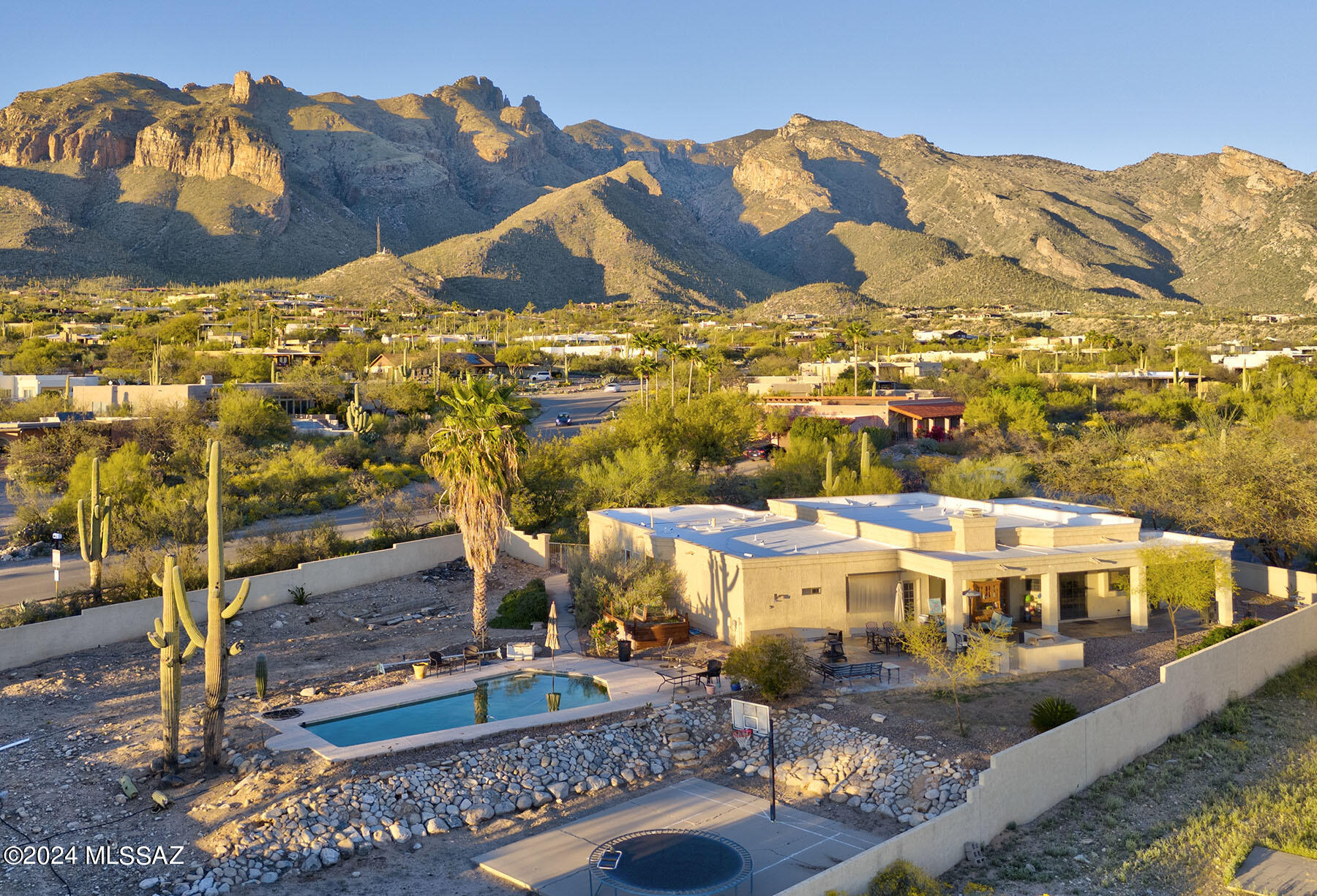 Step into comfort & style with this exceptional home in The Foothills. Nestled on a corner lot, this exquisite property boasts breathtaking Catalina Mountain Views that will leave you in awe every day. As you step outside, you'll be greeted by a sprawling yard, perfect for outdoor entertainment and relaxation. Imagine hosting unforgettable BBQ parties by the sparkling pool or shooting hoops on your very own basketball court. With plenty of space to roam, unwind and enjoy the night city lights, this backyard oasis is truly unparalleled. Inside, discover a thoughtfully designed interior featuring 5 bedrooms & 4 baths. The layout includes formal living and dining rooms, ideal for elegant gatherings and special occasions. Revel in the luxury of travertine and maple wood flooring throughout adding a touch of sophistication to every corner of the home. The heart of the residence lies in the expansive kitchen, complete with an island, stainless appliances, and a gas stove top. Enjoy casual dining in the adjacent space, perfectly suited for everyday meals with family and friends. The kitchen seamlessly flows into the inviting family room, where a cozy fireplace awaits, creating the perfect ambiance for relaxation and leisure. Retreat to the remodeled primary bath, where indulgence awaits with a jetted tub, tiled shower, and a huge walk in closet. This tranquil sanctuary provides the ultimate escape after a long day. With it's stunning views, expansive yard, and inviting floor plan, this home truly embodies the epitome of modern living.