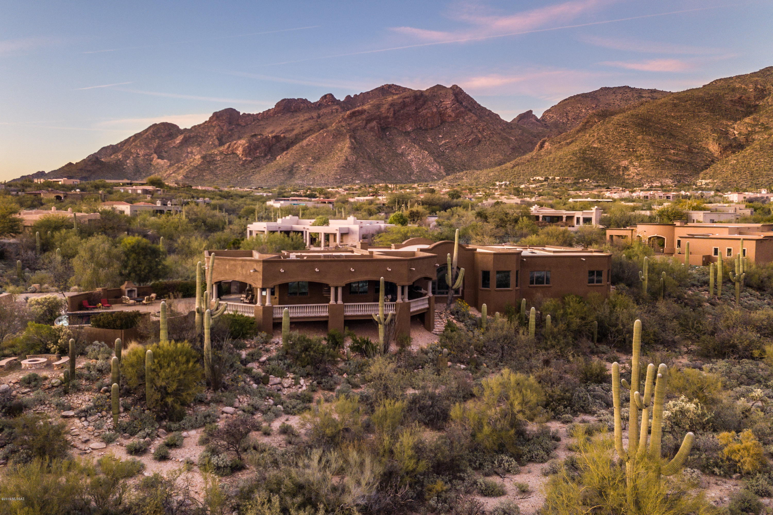 Stunning Pima Canyon home features panoramic views of the mountains and city.   Meticulously cared for, the home boasts a chef's kitchen with Dacor appliances, large island, & choice of breakfast bar or a nook overlooking the desert to sip your morning coffee, split floorplan with glorious master suite (open your eyes in the morning to a gorgeous Tucson sunrise?) Entertainment options abound - the long patio to bbq while enjoying the mountains or city views, the paver pool area with infinity edge pool, spa or fire pit?  Or head up to the roof top deck for a very special 360 degree view.  Relax in the family room and catch up on the latest movies.  The lot is 2.6 acres, so privacy is yours.