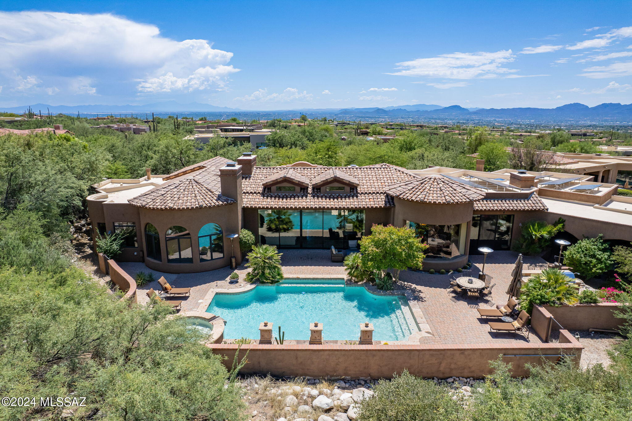 Timeless Tuscan Style 4 BR & 5 BA Custom Home In Coveted Pima Canyon Estates on Premium View Lot. This Exquisite Home Offers a Courtyard Entry w/Fireplace,Open Floor Plan,Living & Dining Room w/Retractable Wall Of Windows That Instantly Transforms the Indoor & Outdoor Living Space,Granite Kitchen that Opens up to Family Room, 3 En-Suite Guest Rooms Including Separate Guest House,Primary Suite w/Fireplace, Oversized Walk in Closet, & Exercise Room.Other Fine Features Include an Executive Office, Gallery Hall for Art,Spacious Wine Cellar, Soaring Wood Beamed Ceilings,Tumbled Travertine And Hickory Wood Floors, 4 Bay Garage & Owned Solar Panels. Private Outdoor Living Space Includes Fireplace,Built In BBQ & Bar, Stylish Pool & Spa w/ 3 Canterra Stone Water Falls. EXCEPTIONAL MOUNTAIN VIEWS!!