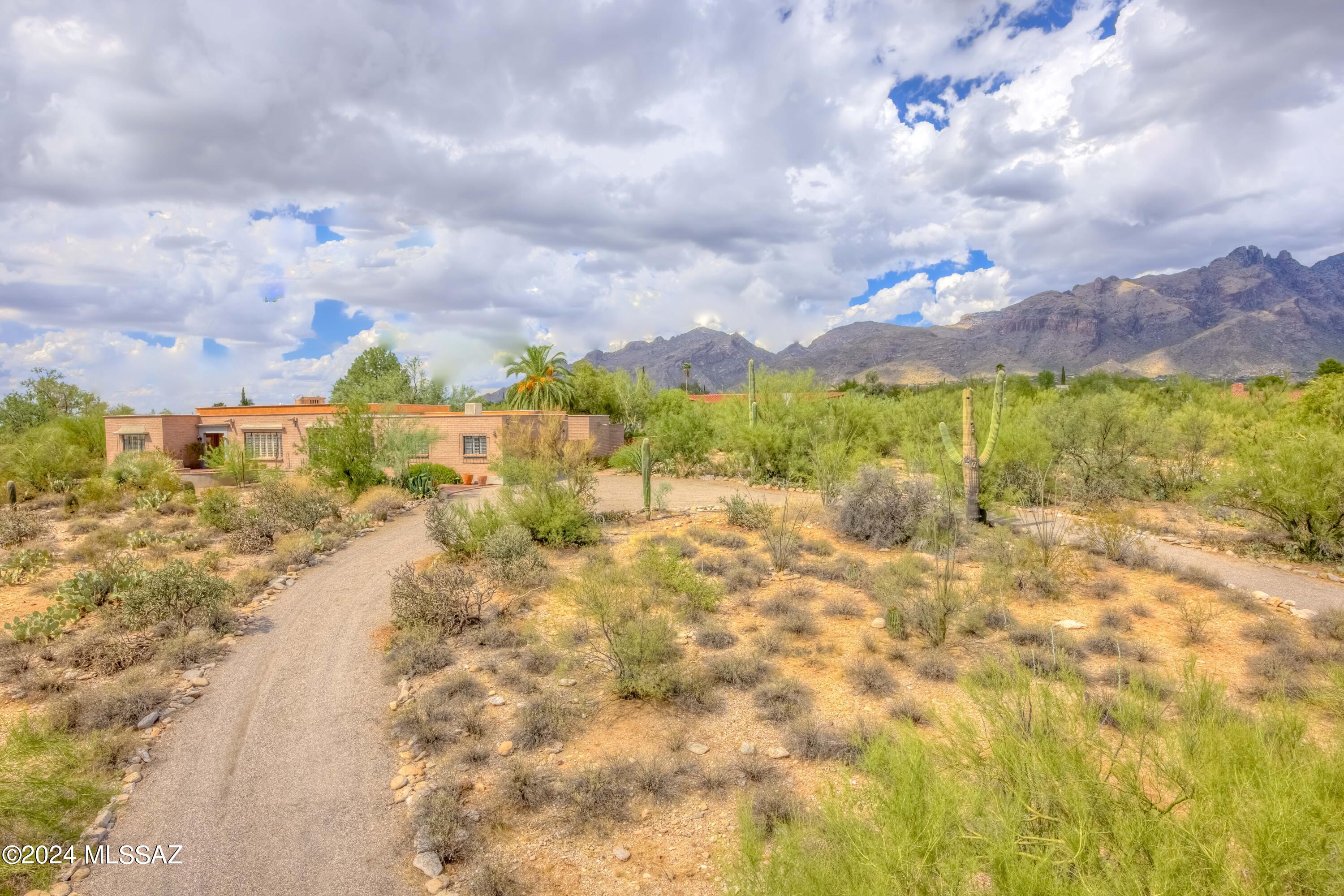Spacious burnt adobe home on large 1.43 acre lot on a Catalina Foothills Estates cul-de-sac! Dreamy garden oasis with sparkling swimming pool, great views and excellent school district! Split bedroom plan offers four bedrooms/three full bathrooms and well maintained Saltillo floors. Primary suite has its own entry and could be private guest quarters. Roomy garage has separate evaporative cooling system and workshop area for hobbies and tools AND plenty of storage. Water softener system and drip irrigation are added bonuses. Large covered patio and established, mature vegetation abound for shady entertaining. Custom cabinetry throughout this home. Classy formal dining room. Kitchen has granite countertops and all appliances. There are many living spaces in this home; room for everyone!