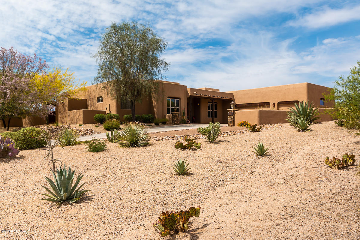 Stunning view home on a private elevated lot with incredible mountain & sparkling city views. Home offers 3,476 sqft, 4-BR/4-BA, office, & 3-car garage on more than an acre. Enter this gorgeous house & feel the excitement of the grand great room with beautiful viga wood-beamed ceilings & captivating views. Features include tile flooring throughout, solid alder doors & cabinetry, architectural niches, high ceilings, 2 fireplaces & designer fixtures. Gourmet kitchen w/custom cabinetry, SS appliances & granite counters. Sensational resort-style backyard designed by architect Joe Prchal is a breathtaking private paradise w/an amazing pool, travertine tile, gas fire pit & a spacious shady patio. Perfectly located in southern Oro Valley, close to shops & restaurants, with easy access to I-10.