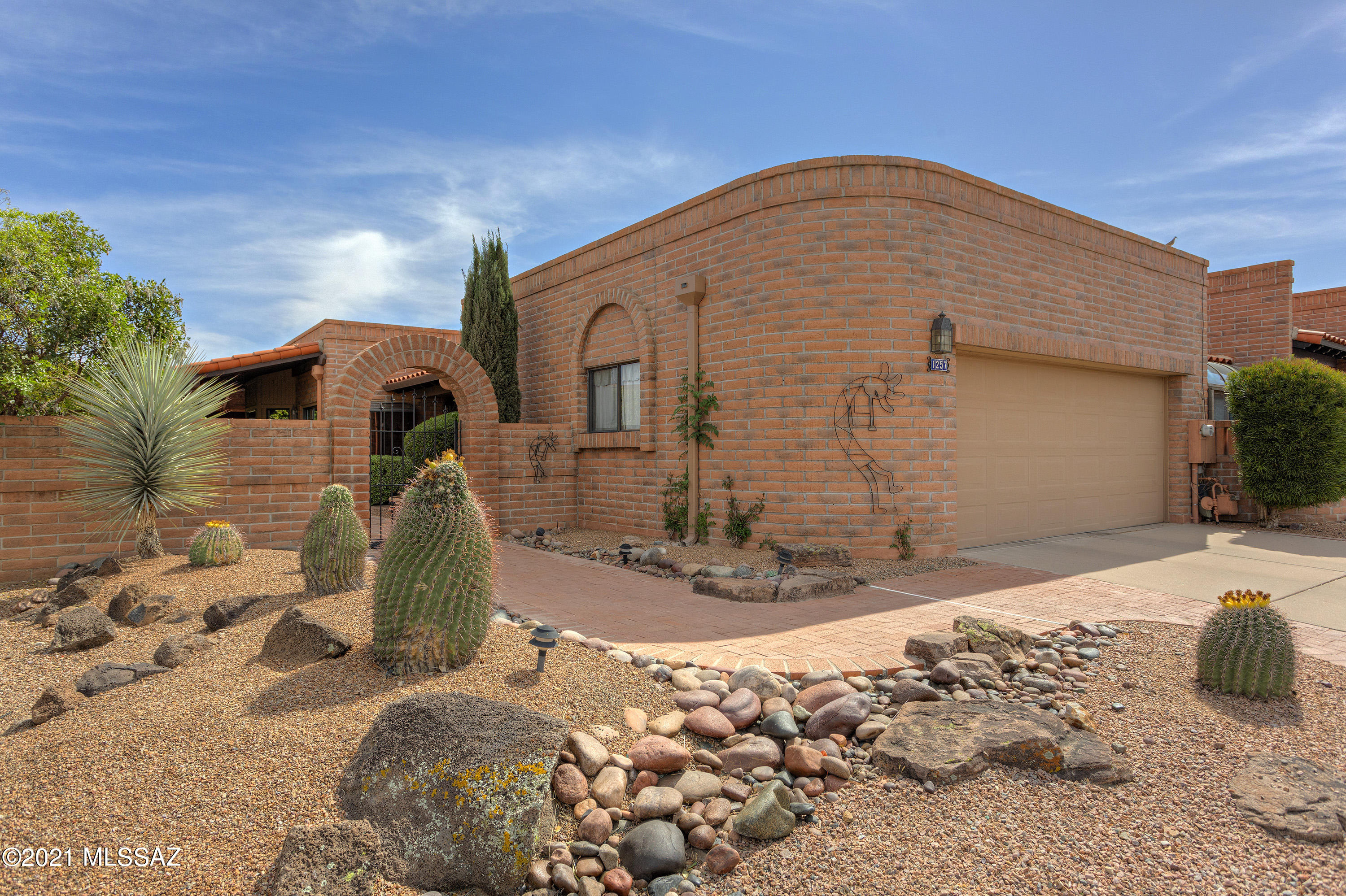 This is the one you've been waiting for! Mountain view; beautiful front courtyard; wraparound covered patio; extensive outdoor living space with water feature and inside a comfortable, spacious floor plan! You'll enjoy the updated kitchen with granite countertop, breakfast bar, pull-outs and stainless steel GE Profile appliances.  There's a nook with a garden window overlooking the courtyard with fountain where you can enjoy your morning coffee inside and a sliding door to the covered side patio. This home has a grand living room area with a gas fireplace trimmed with a mesquite mantel. A wall of sliding doors brings the outdoors in as well as the panoramic view. The expanded den/office area is through double doors off the entry and offer comfort as well as workspace. Down the hall is the huge master suite with sliding doors to the outside covered patio that also bring in natural light and the mountain view. The master bath has a large walk-in closet, dual vanities with granite countertops and a tiled walk-in shower. Instead of a tub there is a large linen closet for storage. The guest suite is on the north side of the house and opens to an enclosed sunroom. Your guest can enjoy the privacy of their own private patio. This home has plenty of Hunter Douglas blinds throughout, ceiling fans and skylights. There's even one in the garage. The drip system was replaced throughout the yard in 2020. The slump block bricks were sealed in 2020 and the house trim was painted. The HVAC was new in about 2015. A new hot water heater was installed in 9/20 and the Kinetico Water system located in the back storage room is about 2-3 years old. The roof has been regularly maintained by Trinity Roofing as recently as early this year.