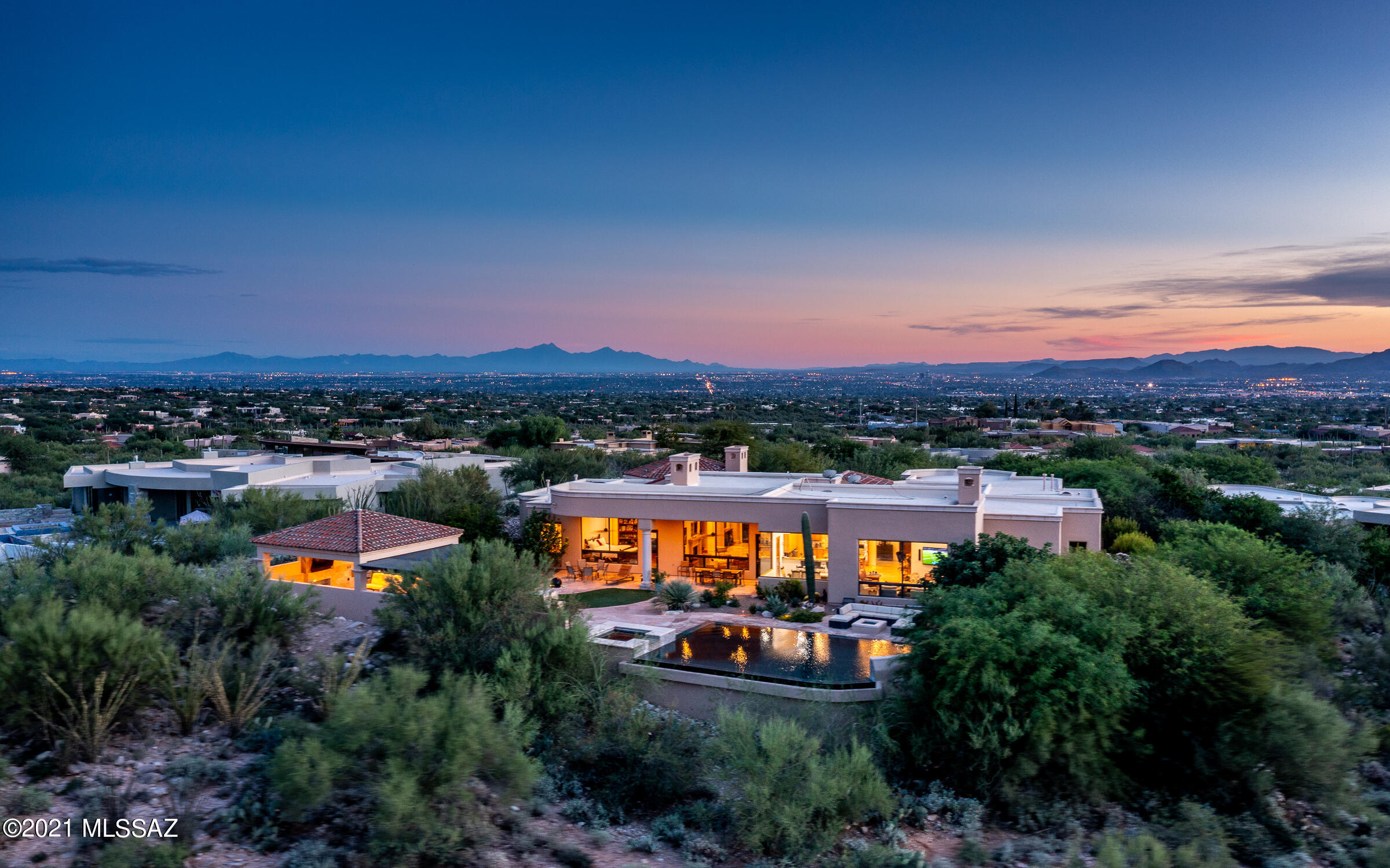 Sophisticated Mediterranean Estate in sought after gated Pima Canyon. Incredible 5,985 sq. ft. master piece, built by Hillcrest Homes with the finest quality materials & finishes. It was designed for fine living with an open, flowing floor plan featuring timeless elegant upgrades, 4 en-suite bedrooms, a multi-functional exercise room + a private guest house, currently being used as a large home office. The gourmet kitchen has butternut glazed maple cabinetry, high-end appliances & a casual dining area. Relish in the expansive views and relax near the many cozy fireplaces. This home has it all including a resort style backyard for total outdoor enjoyment & entertaining, boasting an extended covered patio, Ramada and negative edge pool overlooking the the Catalina Mountains!