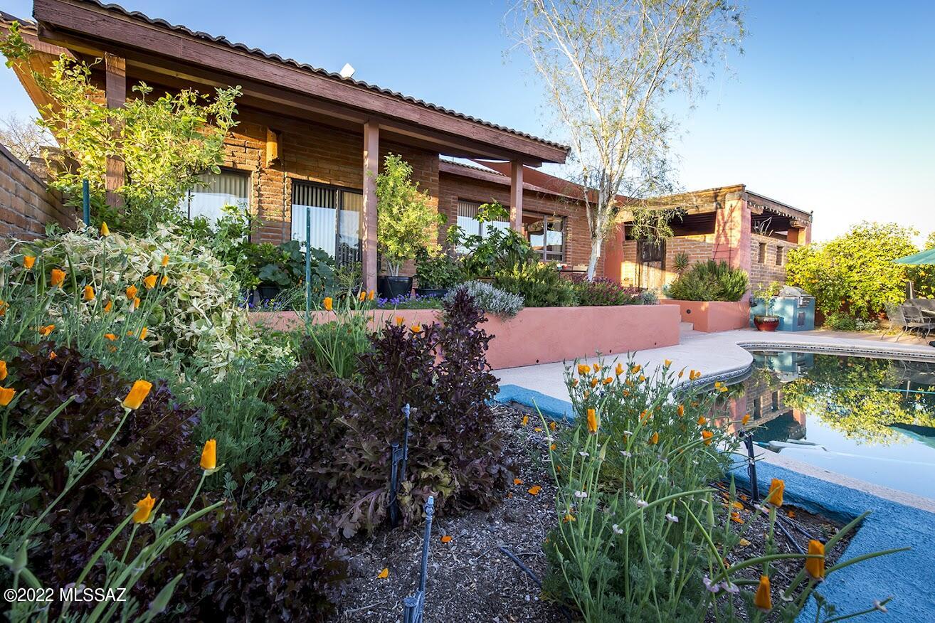 Stunning location!  The multi-level floorplan allows for incredible views of the City from the open living room and kitchen too.  Views from the back of the home are of the Catalinas, Finger Rock trail is right there for your morning hike if you're so inspired. Spacious,  thoughtfully remodeled and impeccably maintained for twenty years, it now can be yours!   Hardwood floors, vaulted wood ceilings, newer kitchen, four bedrooms and three baths, plus a wonderful bonus room for office, family room with exposed brick and wood.  Property is fenced and walled for privacy and to keep out desert critters, with lush desert landscaping and gorgeous flowering gardens; lot extends beyond back fence with natural desert. The outdoor spaces are lovely, for your private sanctuary & entertaining as well!