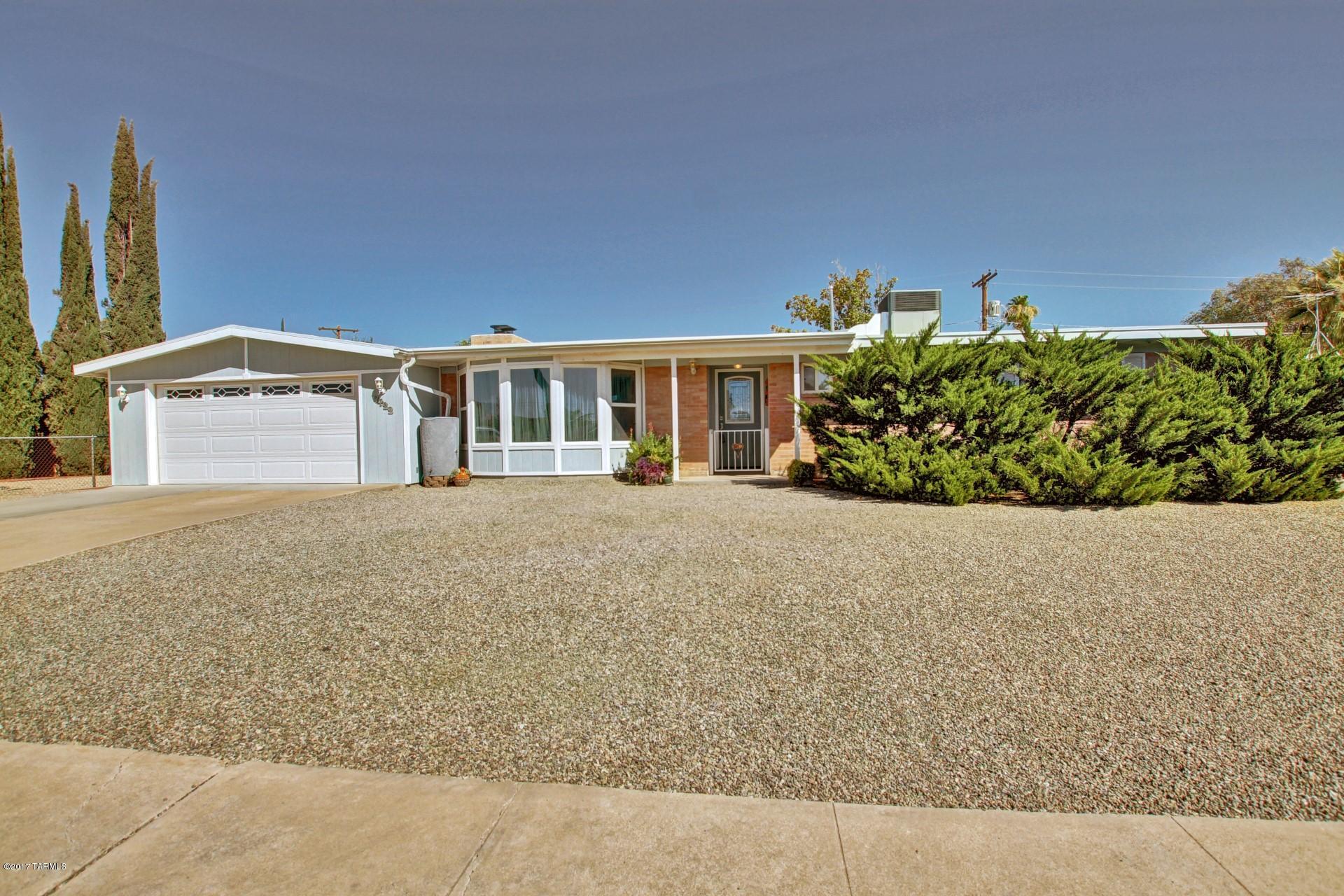 Fantastic Vintage Home with cozy brick fireplace, tile floor throughout, bay windows, neutral palette, skylights, and French doors to Arizona Room. Spacious newer eat-in kitchen features breakfast bar, stylish counters, SS/black appliances,custom wood cabinetry with hardware. Large laundry/mud room with storage cabinets, patio access, and unique light table. Generous size bedrooms, ample closets, and 2 updated baths. Enjoy the Arizona Room with endless possibilities. Peaceful & serene backyard boasts covered patio, grassy play area, mature shade trees, and Mountain Views. TEP Solar , Fixed monthly payment. This well-loved Home is a must see!