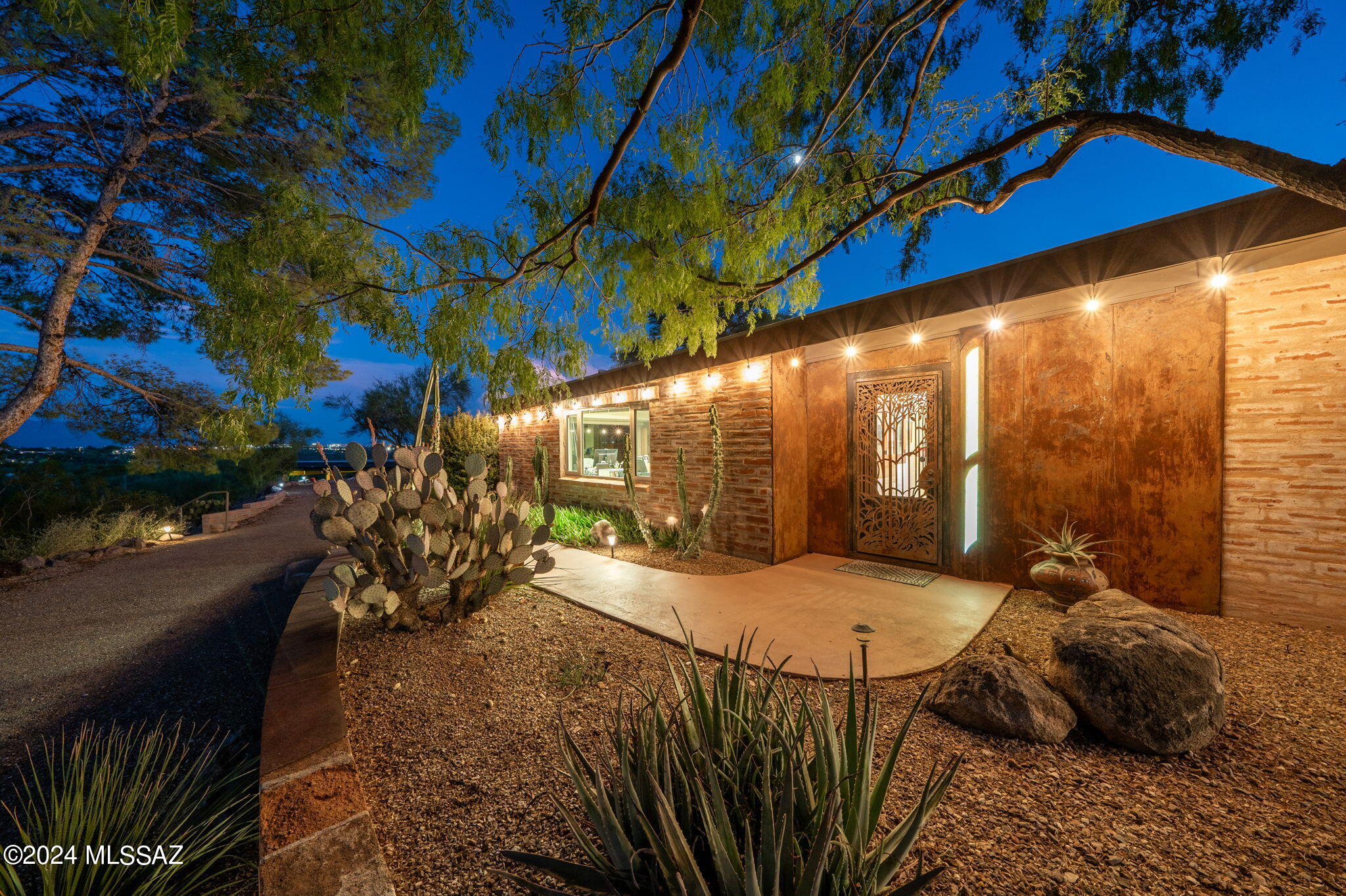 A breathtaking study in architecture- This stunning property has over 5300 sq. ft. of living space with custom details inside & out. Enter primary home & find no detail has been left untouched. The front exterior has stunning metal & glasswork, all custom fitted to the home. Large foyer opens to spacious living room with gorgeous fireplace & stunning mountain views. Next, a lovely indoor raised atrium with skylights that fill the home with natural light & brings the outdoors in. Several other seating areas are tucked throughout. Custom kitchen has handmade glass backsplashes (you'll notice lots of stunning glass features throughout the property- compliments of the previous owner who was an extraordinary glass artist). With ample storage, kitchen also contains ... See MORE tab Richlite counter tops, Wolf stove, Sub Zero fridge & custom pantry closet with ingenious moving cabinets to make reaching anything a breeze. Formal dining room has beautiful custom lighting & a detailed built-in buffet + a wall of windows along the south side invite stunning views of pool & city lights. Breakfast bar sits next to it for casual dining. Enter bedroom wing of the home to find gorgeous concrete flooring, a custom adobe hallway with windows to allow the light from the atrium to pour in. Primary suite has amazing views, large walk-in closet, & an ensuite bath featuring separate shower, tub & more custom glasswork. Two generous guest bedrooms & another full bath + tons of extra closet storage are just down the hall. On the other side of the kitchen you'll find a family room w/ custom metal fireplace, city views & a breakfast nook. Large laundry room & half bath lead into former guest house, now an enormous library & generous enough space to use for office, family room or whatever your heart desires.
In the backyard is a sparkling pool, impeccable landscaping & breathtaking views- courtesy of a N/S facing home. On almost 2 acres, there's plenty of room for entertaining. Walk up a little pathway & you'll come to the second home. This beautiful guest house boasts 2 bedrooms, 1 full bath (plus an accessible shower), a full kitchen, dining & living room- PLUS an enormous 3 car garage. Beautifully built home has soaring wood beam ceilings inside & out. Kitchen is bright & airy with beautiful southwestern tiles, gas stove & more. Home has a separate entry to the garage & private front door with courtyard. Property has Custom ceiling fans throughout, all newer HVAC systems & hot water heaters. And best of all main home has fully paid solar. Close to everything and yet total foothills privacy. Come see today.