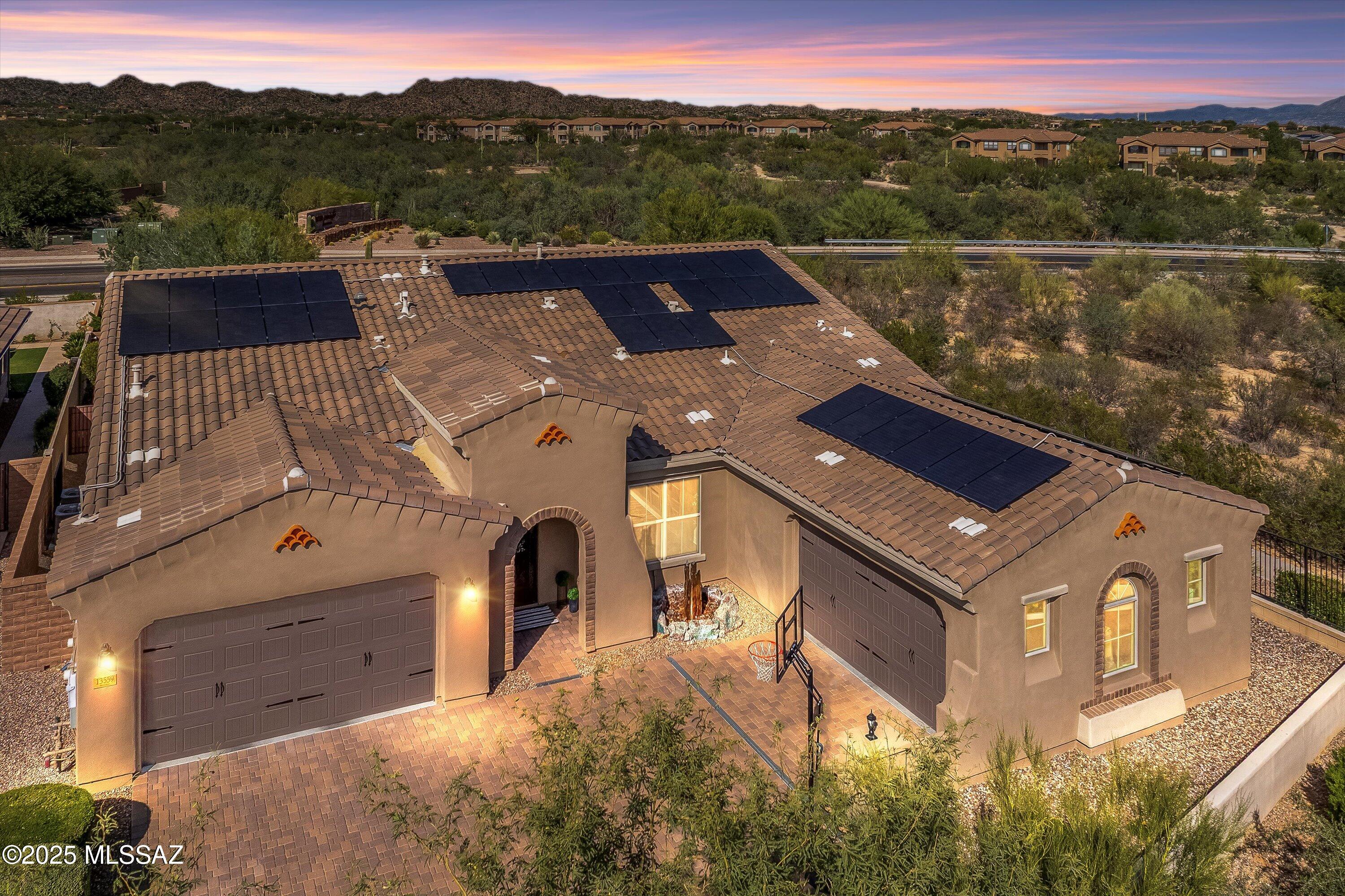 Welcome to a home where luxury, design, and desert beauty come together effortlessly. Set behind the gates of one of Oro Valley's most desirable communities, this 4-bedroom, 3-bath residence with two additional flex spaces, a 4-car garage, and a resort-style pool sits on over a quarter-acre lot and offers more than 3,600 square feet of refined living with breathtaking Catalina Mountain views. Every space has been thoughtfully updated and designed for both style and functionality — a true retreat that redefines modern desert living.
From the moment you step inside, architectural details make a statement — coffered ceilings, arched walkways, and a custom iron entry door set the tone for the elegance that continues throughout. The open-concept great room draws you in with soaring ceilings, custom built-ins featuring 3-way ambient lighting, and expansive windows framing the backyard oasis.
The showpiece kitchen is a chef's dream, boasting brand-new quartz countertops and backsplash, a massive center island with seating, double ovens, gas cooktop, and a custom walk-in pantry designed for maximum organization. Designer lighting and upgraded fixtures flow seamlessly throughout, creating a cohesive and inviting atmosphere.
Enjoy a choice of dining experiences with a formal dining room, a cozy breakfast nook, and a spacious breakfast bar, ideal for both everyday living and entertaining. The split-bedroom layout features four spacious bedrooms, three full bathrooms, an executive office (or flex space), and a versatile media or family room complete with a custom-built wine and coffee bar with a mini fridge. Two of the guest bedrooms share a beautifully remodeled Jack & Jill bathroom, ideal for family or guests, while each bedroom showcases newly installed custom closets by California Closets. All three bathrooms feature tiled showers, premium fixtures, and elegant finishes.
The primary suite serves as a private retreat with a spa-inspired bathroom, dual vanities, and a large walk-in shower. Its oversized custom California Closets walk-in closet offers abundant storage and direct access to the beautifully appointed laundry room with added cabinetry and sink a thoughtful, high-end detail that blends comfort and practicality.
Step outside to your private backyard paradise a modern geometric pool with stacked-stone water features and symmetrical raised planters, creating a tranquil resort-style escape framed by Catalina Mountain views. Surrounded by lush desert landscaping, mature citrus trees, and multiple seating areas, this home is an entertainer's dream. The covered patio extends the living space outdoors, offering the perfect spot to relax or host gatherings under Arizona's endless sunshine.
The updates continue beyond the living spaces with fresh exterior paint (October 2025), epoxy-coated garage floors, overhead garage storage, and a rare four-car garage offering exceptional space for vehicles, tools, or hobbies. Additional upgrades include OWNED solar panels, custom accent walls throughout, and a new refrigerator with dual ice makers. Every improvement has been completed with purpose, comfort, and craftsmanship in mind.
If you love to entertain and crave space to live, work, and play this is it. The gated community also offers resort-style amenities including a sparkling community pool and splash pad, outdoor fireplace pavilion, playground, picnic ramadas, and wide-open green space surrounded by panoramic mountain views. Perfectly located near Catalina State Park, The Loop, and the best shopping and dining Oro Valley has to offer, this home embodies elevated desert living move-in ready, beautifully upgraded, and absolutely unforgettable.