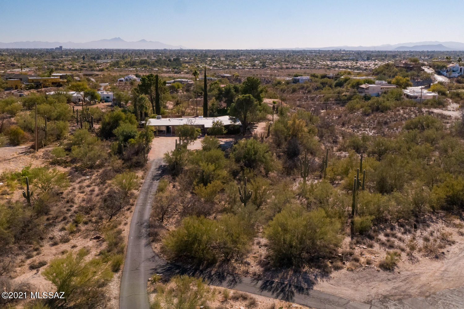Beautiful adobe home on over three and a half acres in a fantastic location! Exposed beams, vaulted ceilings, and guest quarters! Bright and spacious great room boasts a cozy, brick surround fireplace! Stunning formal dining room with saltillo flooring. The kitchen boasts custom oak cabinetry, newer stainless steel appliances, and breakfast bar! Family room right off the kitchen, plus library with built ins! So much living space in this home! Main house boasts three bedrooms and two baths. One bedroom, one bath guest quarters with kitchenette and private entrance! Huge Arizona room, the perfect place to enjoy the Arizona weather. Backyard desert oasis complete with sparkling pool, mature vegetation, plus large flagstone patio! This is a must see home!