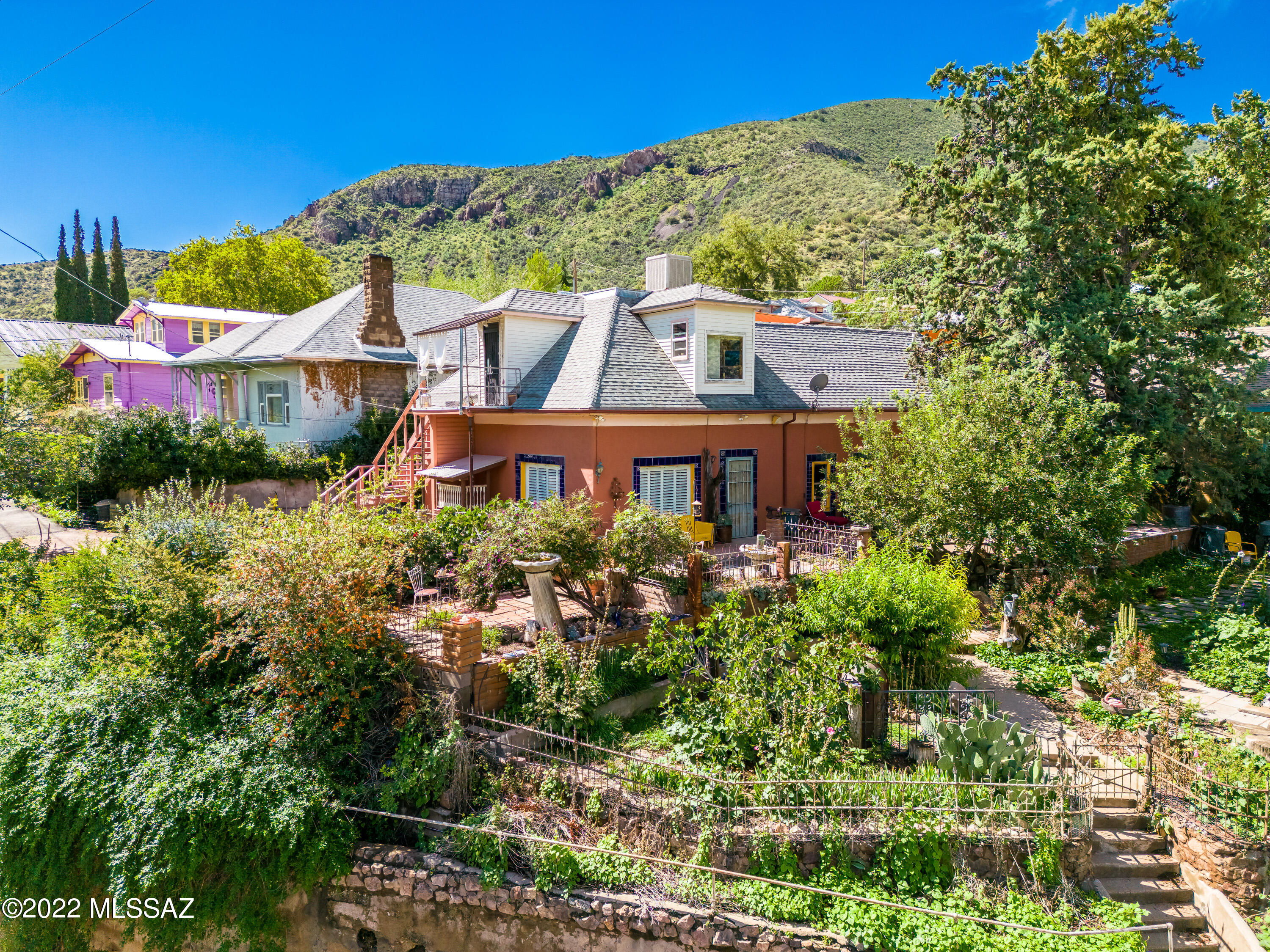 Historic Grand Territorial Style Double Adobe on Quality Hill built in the late 1800s. The Overlock home has been in the same family for almost 100 years & has gone through many transformations & upgrades to become the beauty it is today while still remaining true to its origins. Home to some of Bisbee's most notable residents, historic & current. 3 bed, 2 bath, large eat-in kitchen, formal dining, central heating & cooling & views to live for. Plus a 634 sq ft 1 bed 1 bath with full kitchen apartment upstairs with private exterior staircase perfect for long-term rental or Airbnb. Such a rare find sitting high above Tombstone Canyon on an extra large lot with drive up access & a private driveway large enough for 4 cars, in addition to a 4 car garage located below on Tombstone Canyon. Wow! Beautiful French Potager garden, fruit trees, raised beds for flowers and vegetables, front row view to the renowned Buzzard Roosting Tree, & varied outdoor spaces on multiple levels bring even more peace & elegance to this wonderful home. Located in the heart of Old Bisbee's Historic District, centrally located, easy access to restaurants and downtown. Classic, historic, solid. Own a piece of true Bisbee history. Well maintained and loved, sold as-is.