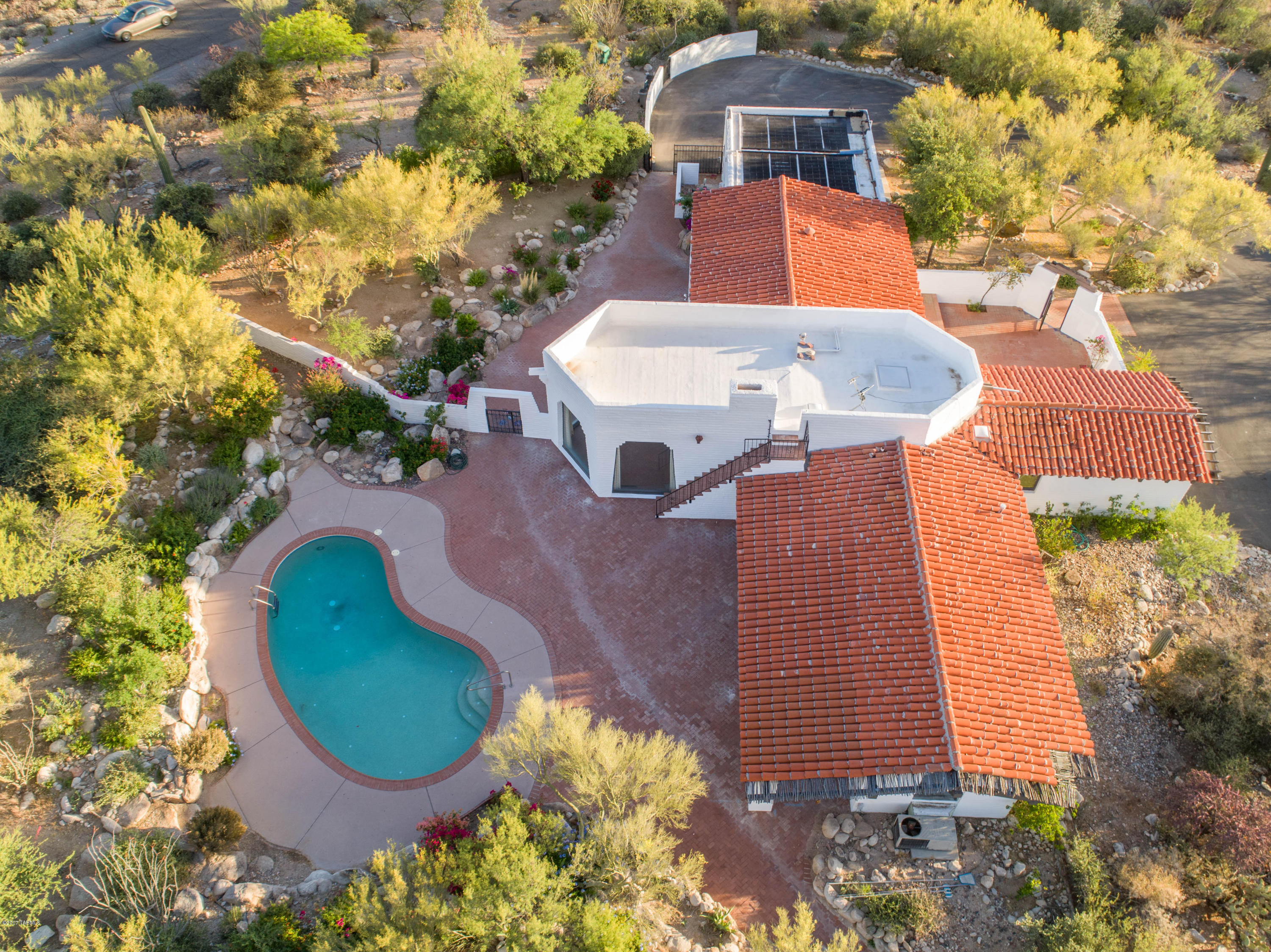 If you are looking for charm-this is it. The best lot in the foothills with almost 9 acres of land. Amazing 360*views. solar heated pebble tech pool,rooftop observation deck.Amazing landscaping includes rose gardens w/extra lighting &plenty of mature fruit trees w/ a 5 valve irrigation system & extra water access throughout property. Gated front courtyard w/brick pavers. Spectacular great room w/high ceiling, wood beams, Grand fireplace w/a beautiful mantel acquired from Mt. Lemmon.  Walls of glass surround the great room to capture the beautiful views! Home includes motion detector security system, central vacuum &concrete flooring. Two on demand heaters,newer A/C Zoned unit. The outside of the home is incredible with multiple walking paths,and well manicured landscaping. You will love it