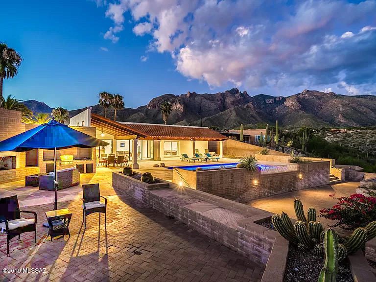 Range Pricing: Seller will accept/counter offers between $897,900 and $924,500.  Immaculate mountainside mansion in the heart of Tucson's Catalina Foothills. Remodeled in 2018, this 4-bedroom, 4-bathroom, masonry-built marvel is perched on a high overlook - with breathtaking panoramic views in every direction (mountain, desert, city, sunrise, and sunset!). Indoor features include tasteful travertine floors, spectacular floor-to-ceiling windows, fully updated kitchen (with granite counters, breakfast-bar, butler-pantry, gas range, built-in refrigerator, and wine cooler), spa-style bathrooms (with marble showers and deep soaking tubs), and massive Owner's Suite with private living area, walk-in closet, and bonus room (great for home office). Outside, find serene sanctuary spaces and exquisite entertainment enclave impressive central courtyard, and stunning terraced grounds (with built-in barbecue and outdoor fireplace) leading from back patio and heated pool. Property is just north of Skyline and Campbell; moments away from premium shopping and upscale dining at La Encantada and St. Phillips Plaza, as well as world-class recreation - like golf and tennis at La Paloma Country Club, plus hikes along the beautiful surrounding desert trails. *See Full List of Upgrades and Spectacular Aerial Video. ***Ask to See More Exclusive Photos Not Listed!