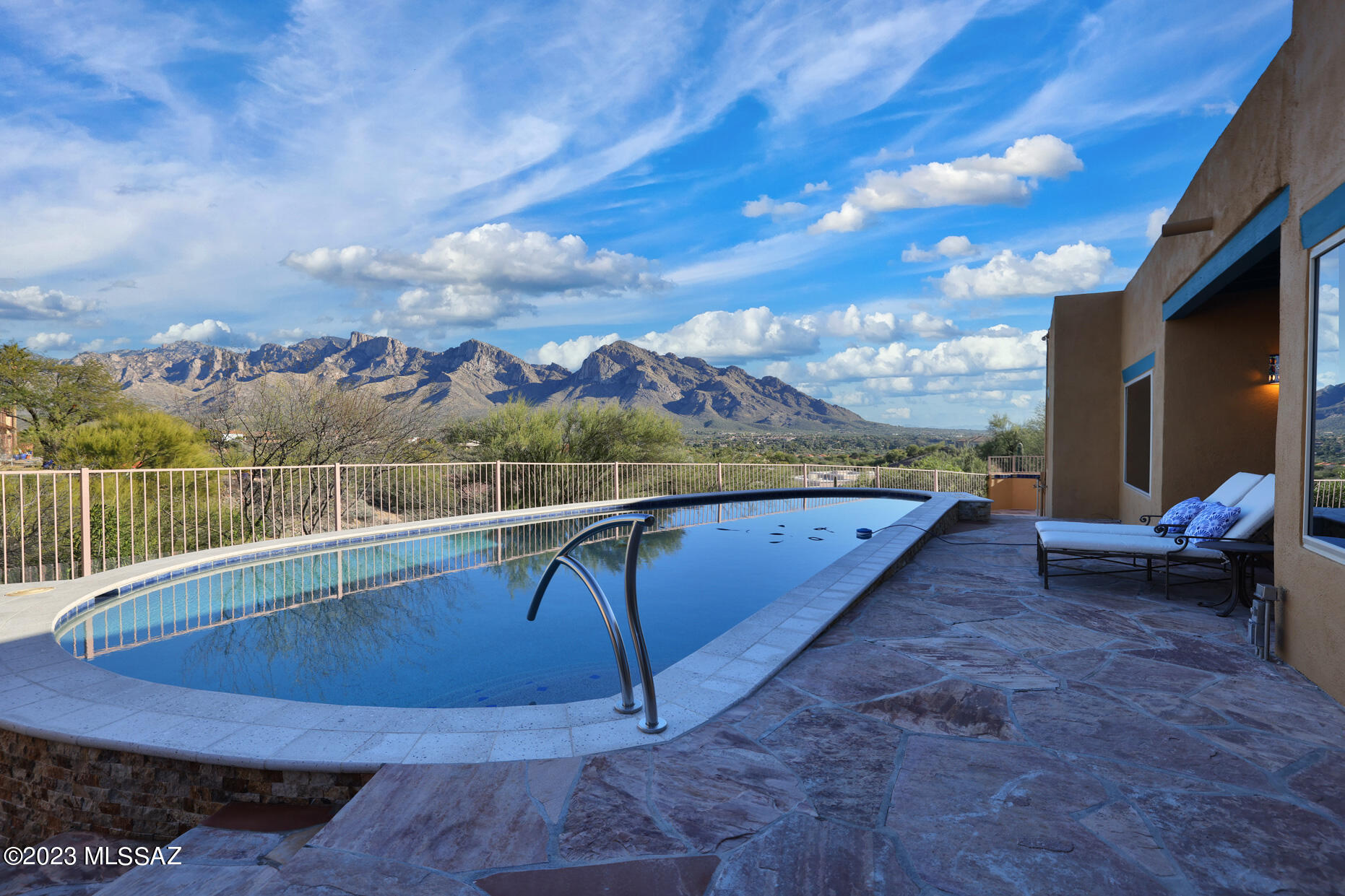 Awaiting you is this classic southwestern retreat, perched high on a hillside in Monte Del Oro, right in  the heart of Oro Valley. Close your eyes and it's almost as if you can feel the ocean breezes, sun on your back and water lapping at your toes. Open your eyes to majestic Pusch Ridge views -- truly stunning each  and every  day  -- and a home that can be both your sanctuary or a gathering spot. Truly one-of-a-kind, with new 40' saltwater pool, owned solar, and flagstone patios with vistas in every direction that surround this 4 bed/3 bath custom home.  Talavera tile, lovingly selected by a previous owner, features inside and out, in true southwestern style. The living room offers high beamed, tongue & groove ceilings with beehive gas fireplace. The kitchen has plenty of storage with pull-out shelves, reverse osmosis, large custom island, SS  appliances including Advantium MW, with both formal and informal  dining areas off to each side. The primary suite is spacious complete with sitting area,  walk-in closet, access to pool area. Views abound here too, whether it's from the sitting area or the also spacious primary bath that is like no other. With a split bedroom plan, the other 3 bedrooms are on the opposite side of the house with full bath and powder room. Outside, there are so many places to enjoy or to gather with friends & family: be it poolside, under the pergola, around the firepit or on the fountain patio to witness a gorgeous sunset. Your retreat awaits...welcome home.