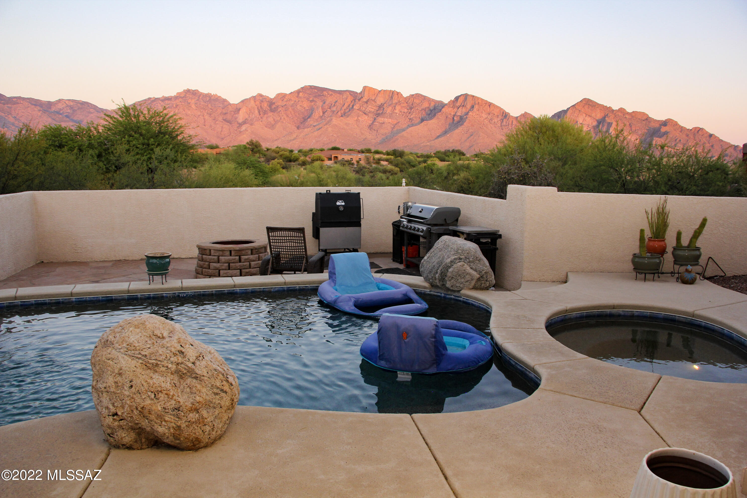 Spectacular Pusch Ridge views of the Santa Catalina Mountains seen in all the main living spaces from this custom home in Oro Valley! Greeted by a front courtyard and grand fountain, this home features a bright and open split bedroom floorplan plus den, 2.5 baths and a 3-car garage. Kitchen offers dual SS ovens, gas cooktop, walk-in pantry and an abundance of cabinets. All appliances stay. On over 1/2 acre and located in a small cul-de-sac, this homes feels very private. Have a hard time with those HOT summer days in Arizona? Take a dip in the sparkling saltwater pool and spa featuring a rock waterfall while enjoying those coveted views as you float along with a cocktail in hand.
