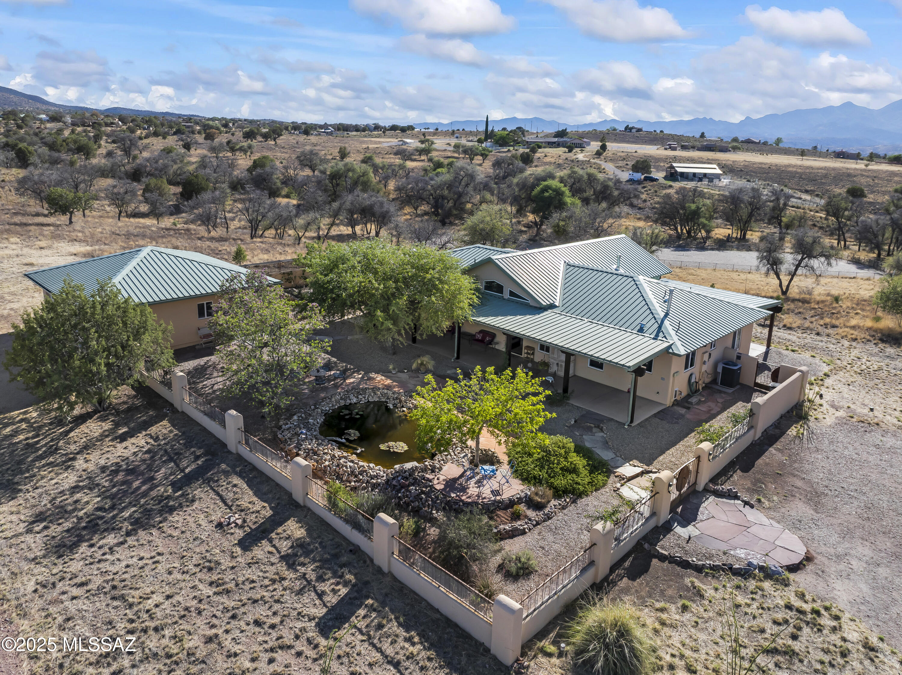 Imagine living in a Sonoita hilltop oasis studded with live oak & surrounded by horse ranches &  nearby wineries embracing the AZ high desert lifestyle! Step into your own 7 + acres, enclosed by an artisan fence, in the highly sought after location of Los Encinos. Entertain on multiple patios offering sweeping 360-
degree views of MTN ranges, including the Santa Rita's, or in your walled courtyard with its serene water feature & lush shade trees. A detached generously sized garage, designed for maximum functionality, is accessed directly from the courtyard Complementing the exceptional grounds, this custom-built home features an elegant interior w/a split floor plan, a chefs kitchen w/SS appliances &  courtyard views.! The
kitchen opens to a masterfully designed great rm w/custom cherry wood built-ins, modern fireplace, slate floors, all with frontal views of Mt. Wrightson. Relax in this magical setting & enjoy spectacular sunsets enhanced by the built-in Bose AV system. There is also a dedicated home office & three Bdrms all with cherry wood floors, the the 2 spacious spa style bathrooms feature dual sinks & Egyptian sandstone tiling & flooring. This home is ready to welcome comfort, beauty & timeless design. Make Offer!
