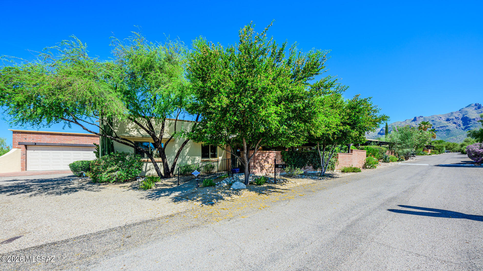 This beautifully maintained 2487 sq ft, 3BR, 2BA, 2-car garage end-unit burnt adobe townhome is perfectly situated in the Catalina Pueblo neighborhood in the heart of the Catalina Foothills. A beautiful & private entry courtyard w/fountain welcomes you to this lovely home w/Saltillo tile floors & high ceilings throughout (carpet in 2 bedrooms). A large, updated kitchen w/island & breakfast nook, leads to the inviting side porch w/natural gas BBQ intertwined w/exceptional lush courtyard landscaping. All rooms have French doors leading to exterior courtyard patios. The primary suite includes 2 separate wall closets & a walk-in closet in the dressing area/bath, adjoined by a separate toilet room & large walk-in shower. The 3rd bedroom/den/library highlights a large natural gas fireplace, custom, built-in cabinetry & shelving & 2 large closets. The oversized 2-car garage provides abundant closet storage w/workshop bench/storage.
